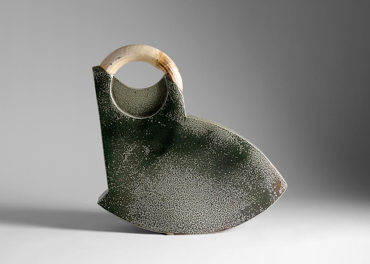 Una delle numerose sculture di Aage Birck in cui l'artista danese ricontestualizza ossa, denti o altri resti semi-viventi, utilizzandoli come dettagli o ornamenti. Con questo pezzo in particolare, ha incorporato una zanna di cinghiale nel suo lavoro.