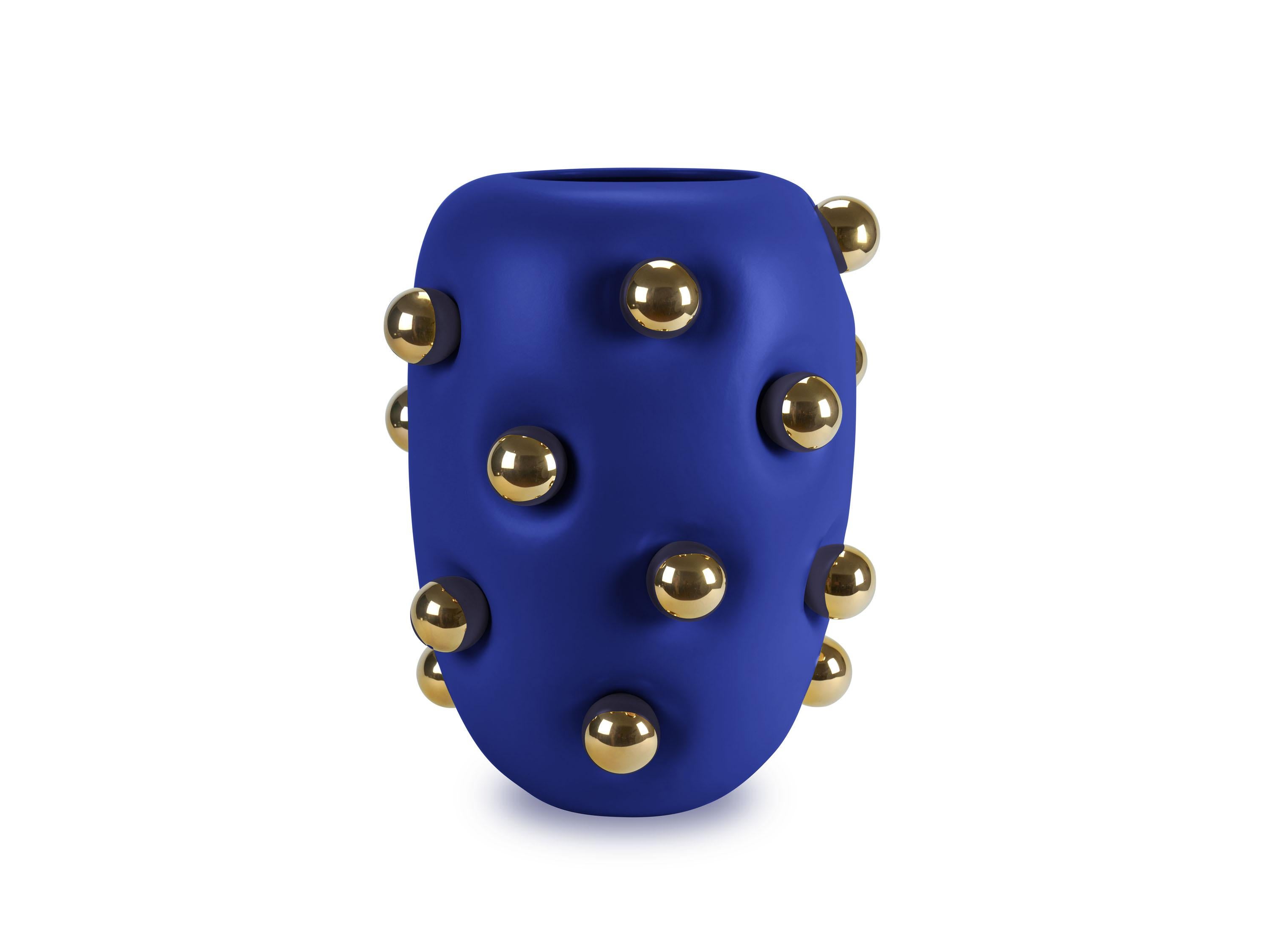 Questo squisito vaso di ceramica di grandi dimensioni presenta un'elegante finitura blu opaca, ornata da 19 sfere di ceramica meticolosamente lavorate, ciascuna placcata in oro a 24 carati. Il corpo del vaso, con la sua consistenza vellutata, sembra
