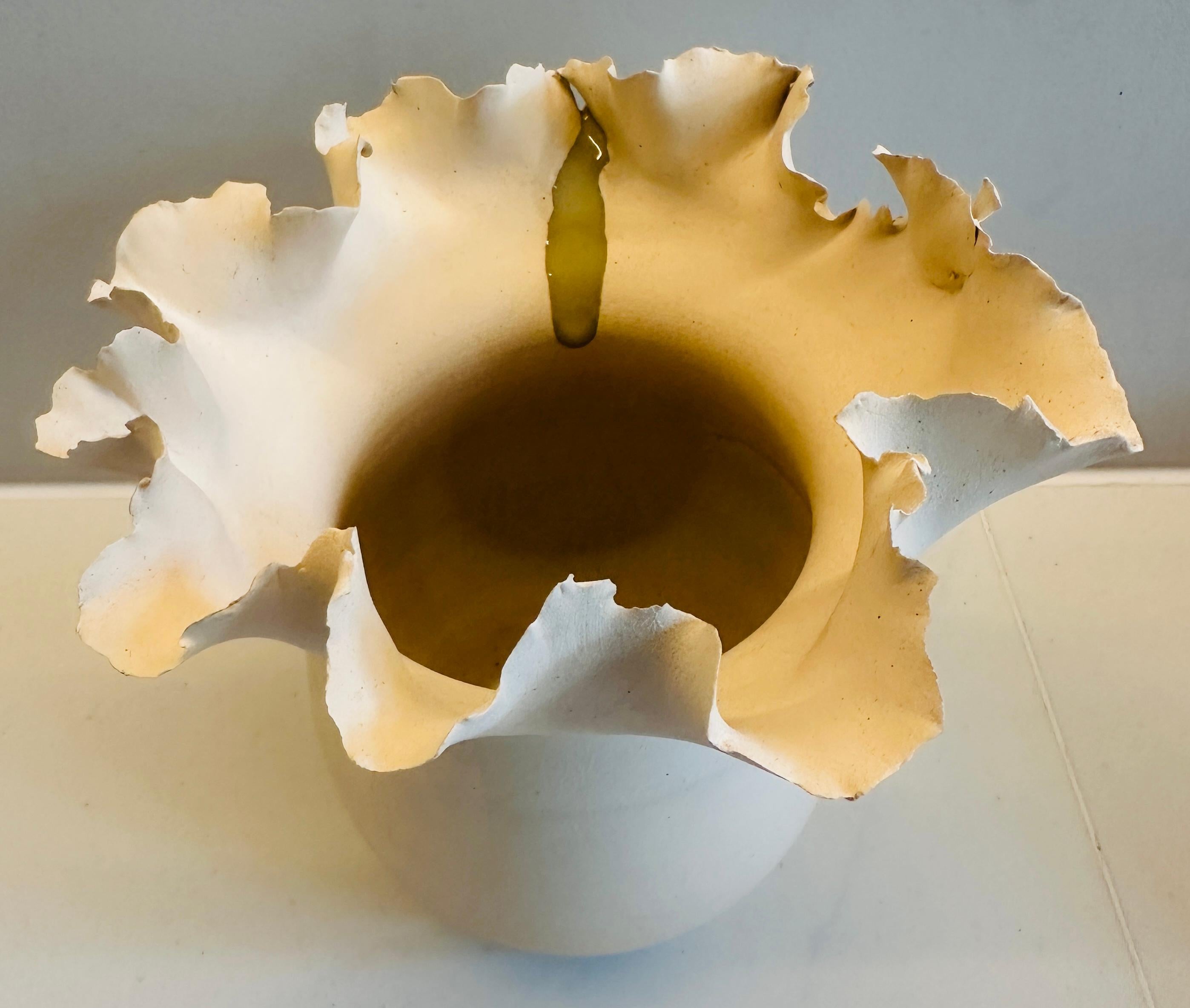 No 10.  Contemporary handmade ceramic natural unglazed stone coloured vase with a waved flower indented rim. A grey polished glazed feature drip flows down one edge of the rim of the vase. Designed and handmade by Brazilian ceramicist Flavio Diogo
