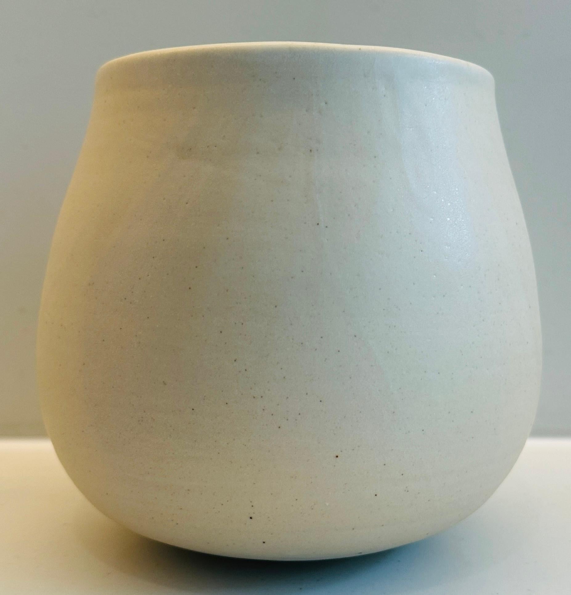 No 47.  Vaso o fioriera in ceramica contemporanea fatta a mano e leggermente smaltata color pietra con un sottile bordo bianco. Progettato e realizzato a mano dal ceramista brasiliano Flavio Diogo di FD21 Clay.

Dimensioni: Diametro: 18 cm Altezza: