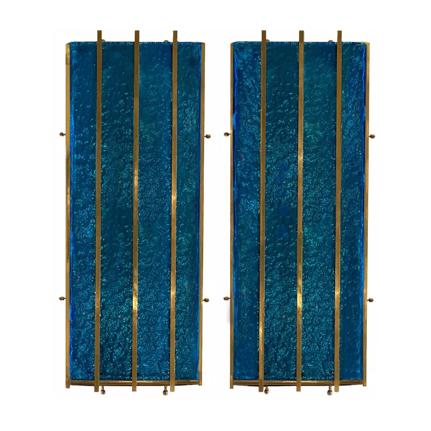 With a nod to the Brutalist style lighting of Longobard of Verona, this pair of  cerulean blue hammered Murano glass wall sconces are elegantly refined by the addition of brass 