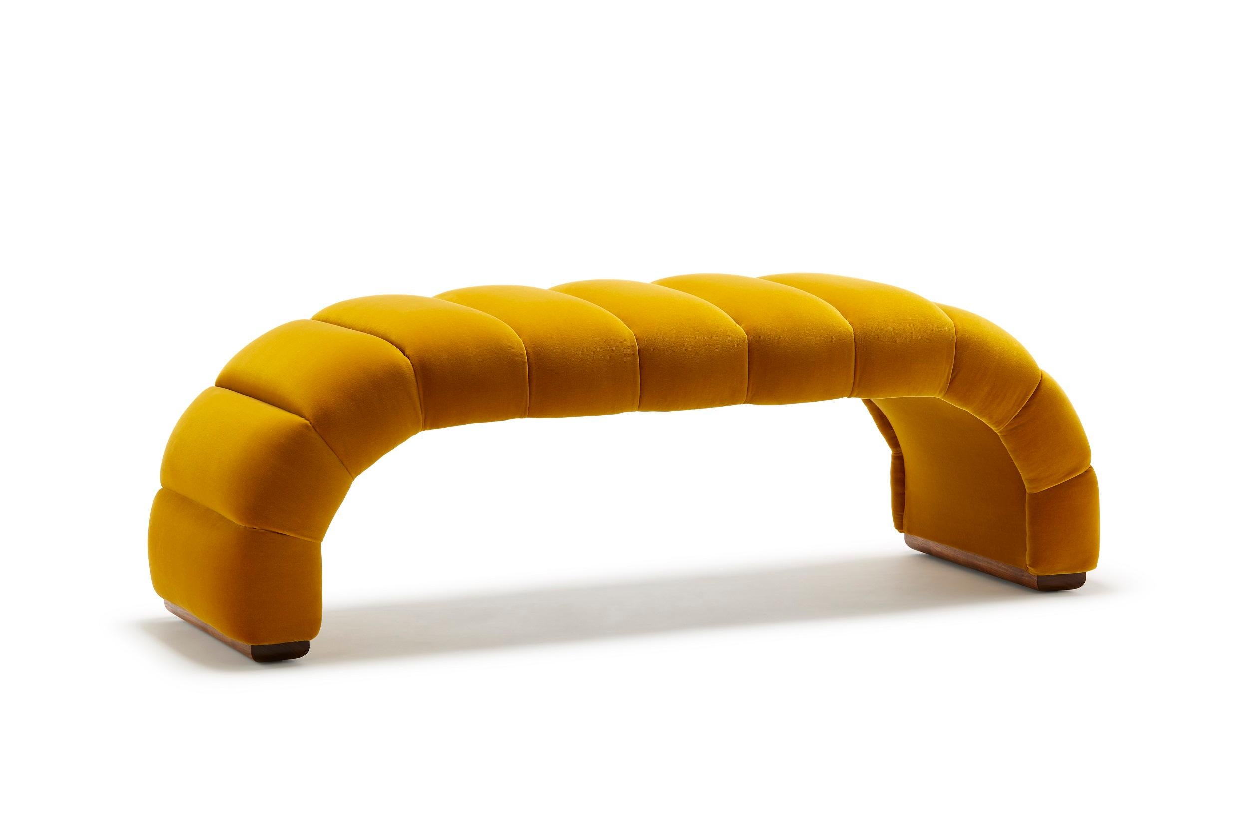 Die Fleure Bench Midi mit ihren tadellosen geriffelten Details ergänzt eines unserer charakteristischen Stücke: Das Fleure Sofa. Hier mit Baumwollsamt Designers Guild Varese Ochre gepolstert, mit Füßen aus geöltem Nussbaumholz, eine Ausführung, die