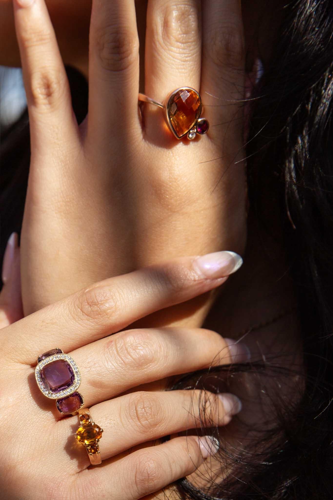 Beautifully crafted in 9 carat gold, The Angie Ring is a stunningly eccentric design. Her golden tear shaped citrine. her purple garnet and her shimmering diamond are wrapped in satiny gold celebrating a love of colour and a rich imagination. 

The