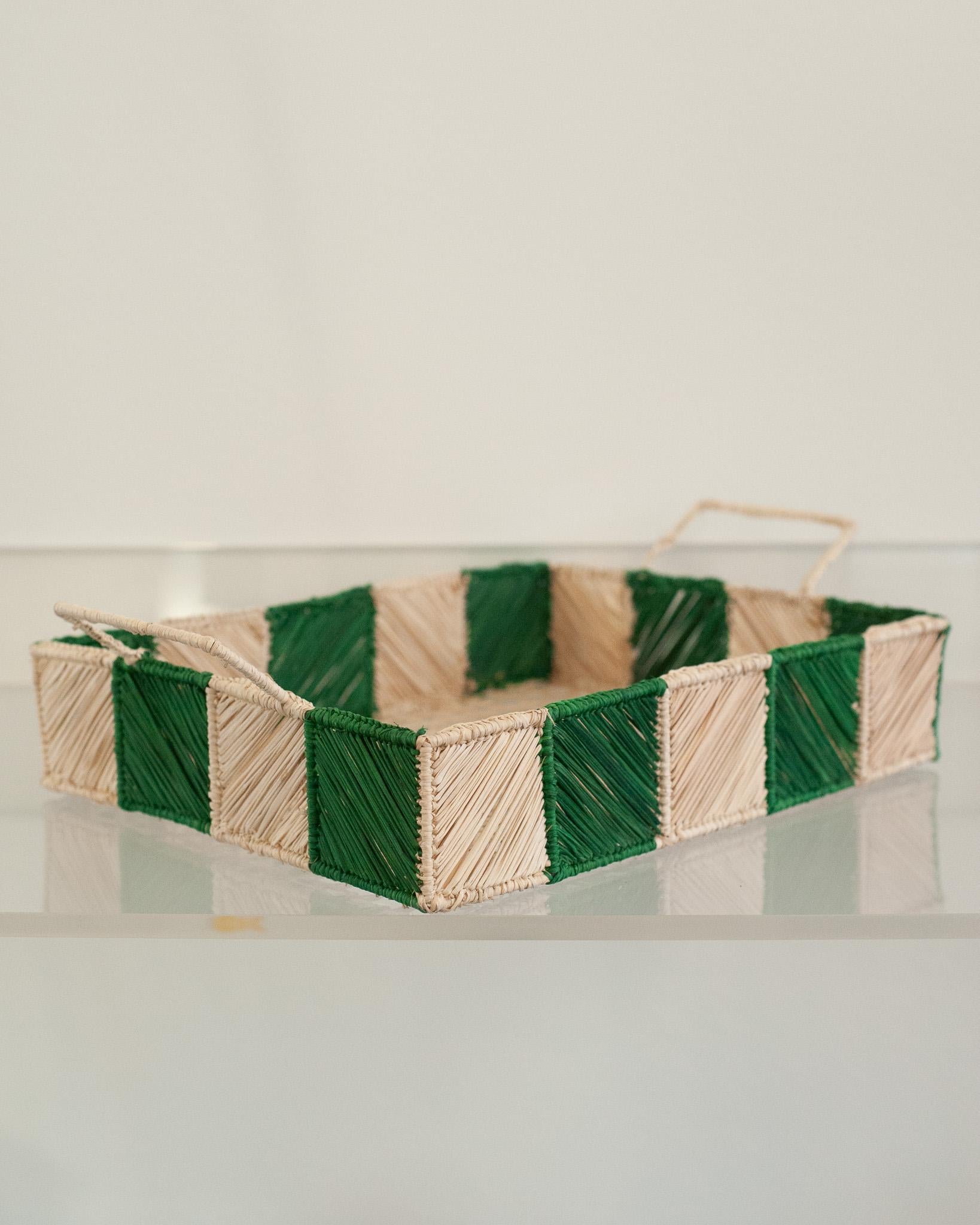 Uplift your table with this stunning handwoven rattan tray with green and natural checkered sides and handles. Finely crafted by expert artisans, this piece showcases the classical technique of weaving in a modern way. From Jean Michel Frank to the