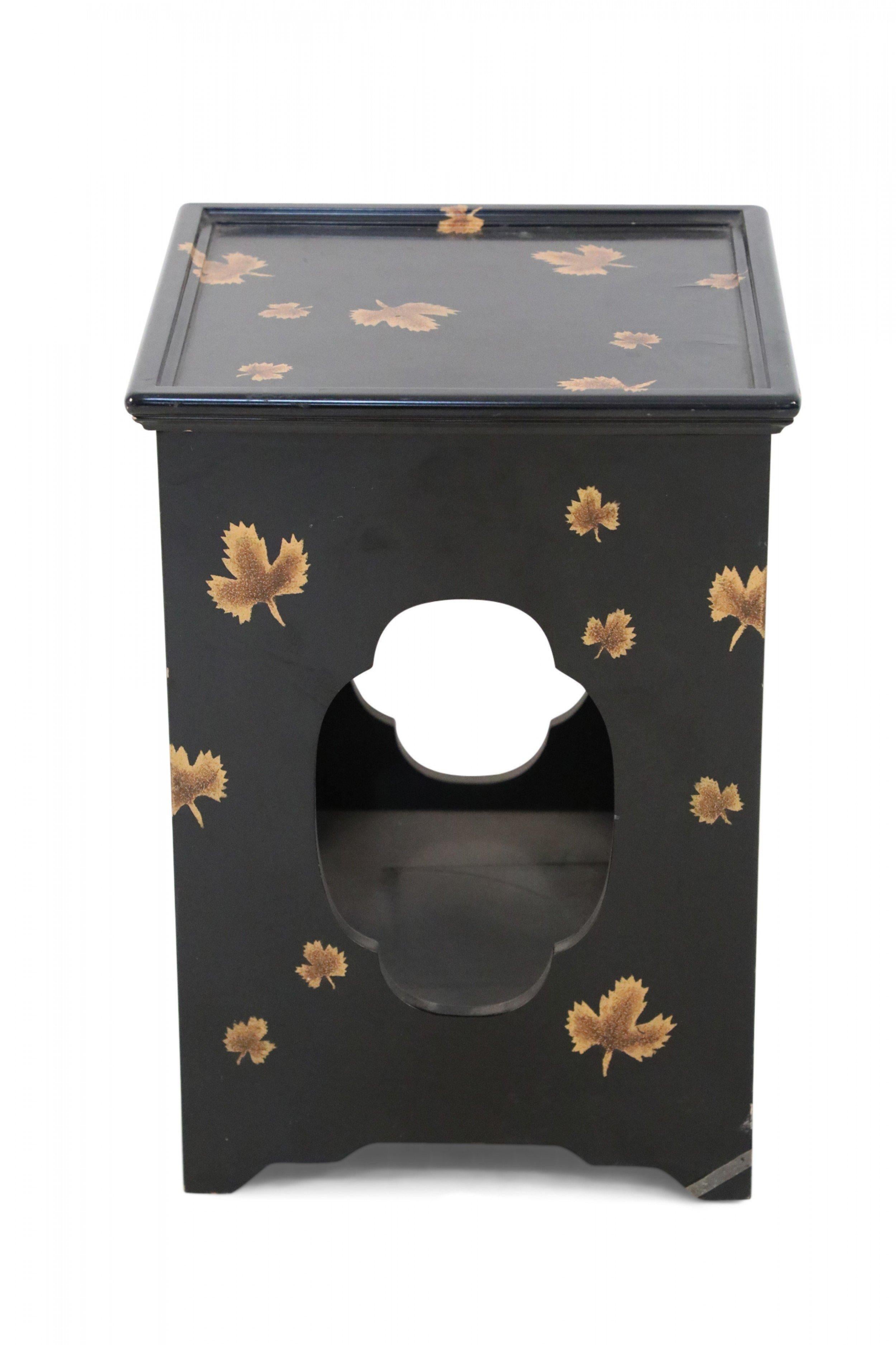 Chinese black lacquer, square side tables distinguished by quatrefoil-shaped cutouts on all sides and a gold maple leaf motif throughout (priced as pair).
  