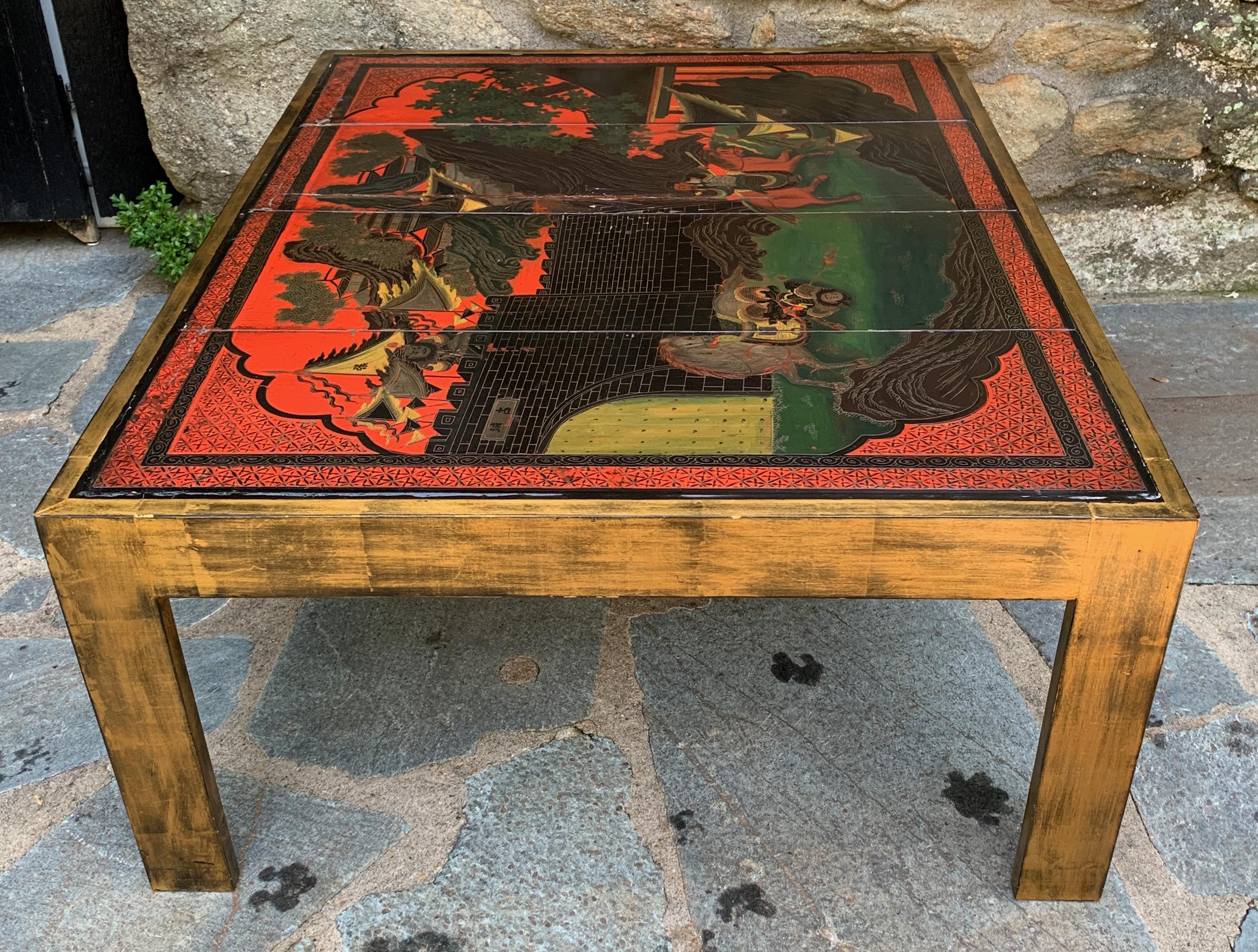 A late 20th century cocktail table fashioned from a Chinese Coromandel screen. The simple square gilt decorated legs supporting the polychrome lacquered surface.
