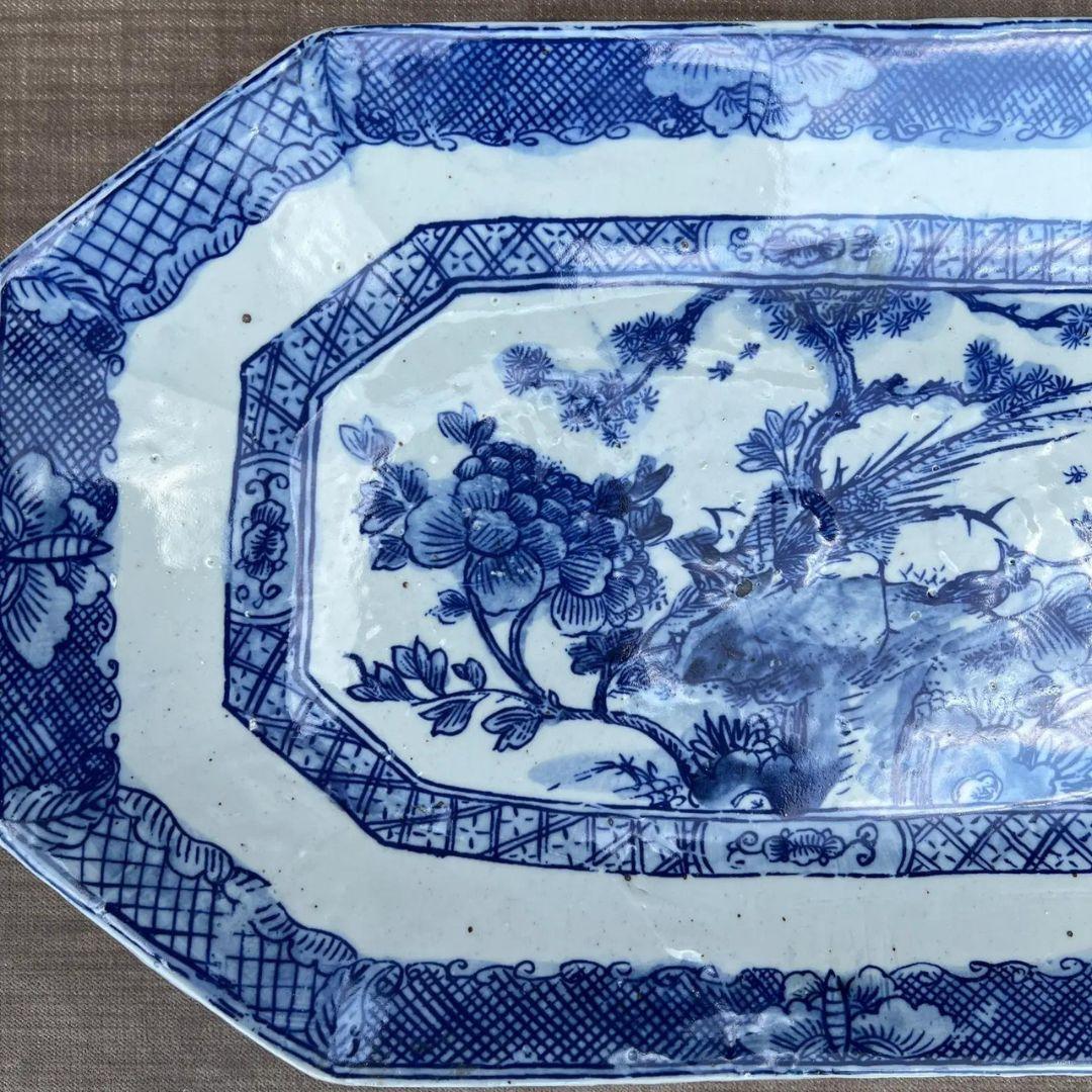 This decorative plate makes a big statement! Gorgeous blue & white chinoiserie ceramic plate decorated with a flourishing flowers and birds. Rectangular shape with cut corners. 

Dimensions: 16