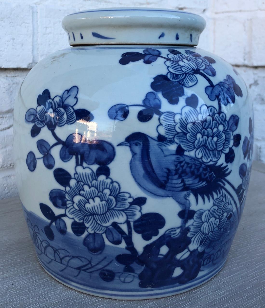 Handmade blue and white porcelain lidded jar with an antique finish. Inspired by the pottery of ancient Chinese empires, this jar will make a dramatic feature when displayed as a centerpiece or on a console table. Painted with flourishing flowers
