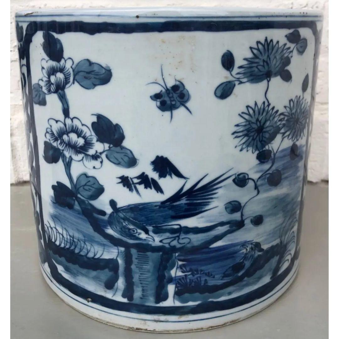 Handmade blue and white chinoiserie ceramic planter with an antiqued finish. This planter is hand-painted with a beautiful scenic window on two sides and a bold floral pattern on the other two sides. Add a fern for a burst of beautiful color or
