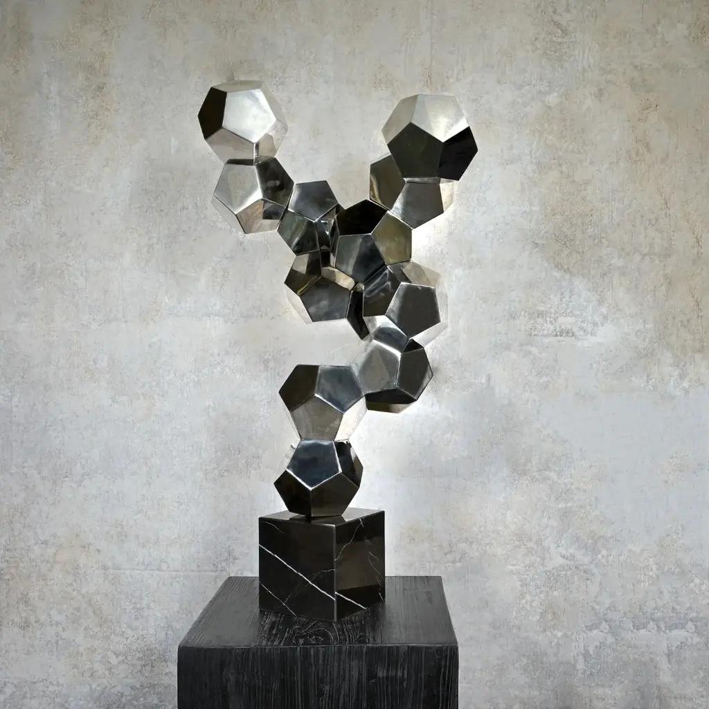 Die Skulptur ist inspiriert von der natürlichen Bildung von Mineralien, die aus geschmolzenen Silikaten entstehen. Seine Struktur besteht aus zwölfflächigen Formen, den so genannten Zwölfecken, die sich zu einer dynamischen und offenen Komposition
