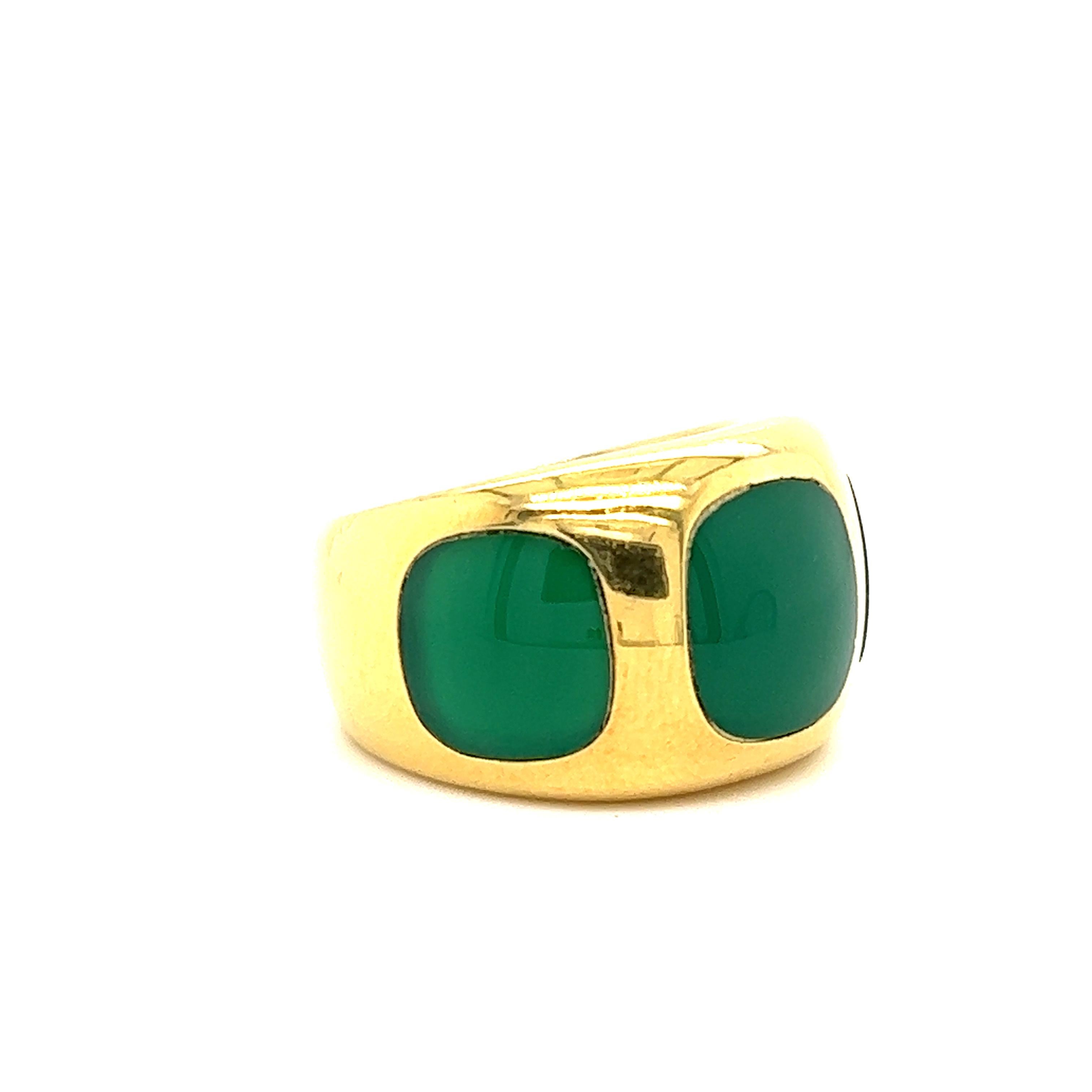 Fantastic design crafted in 18k yellow gold. The ring highlights three chrysoprase gemstones that display a gorgeous green color. The ring is a wide band design that shows a 14 mm top half and tapers down to 8.5 mm at the base of band. The gemstones