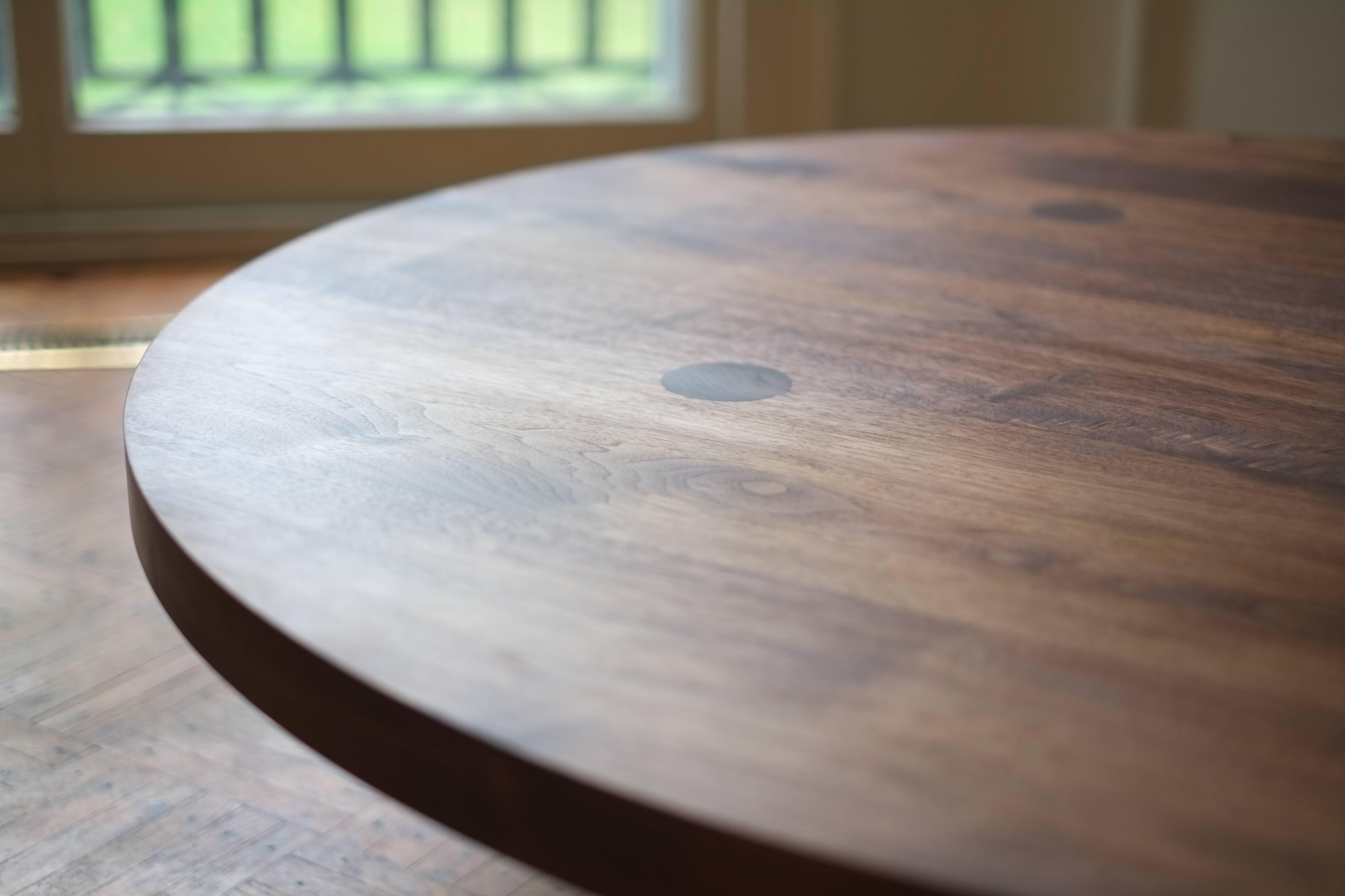 This contemporary, minimal wooden coffee table features four large round legs that pierce the 2 inch thick top to reveal the joinery and remove the need for any other structural components. This detail communicates its solid construction, while