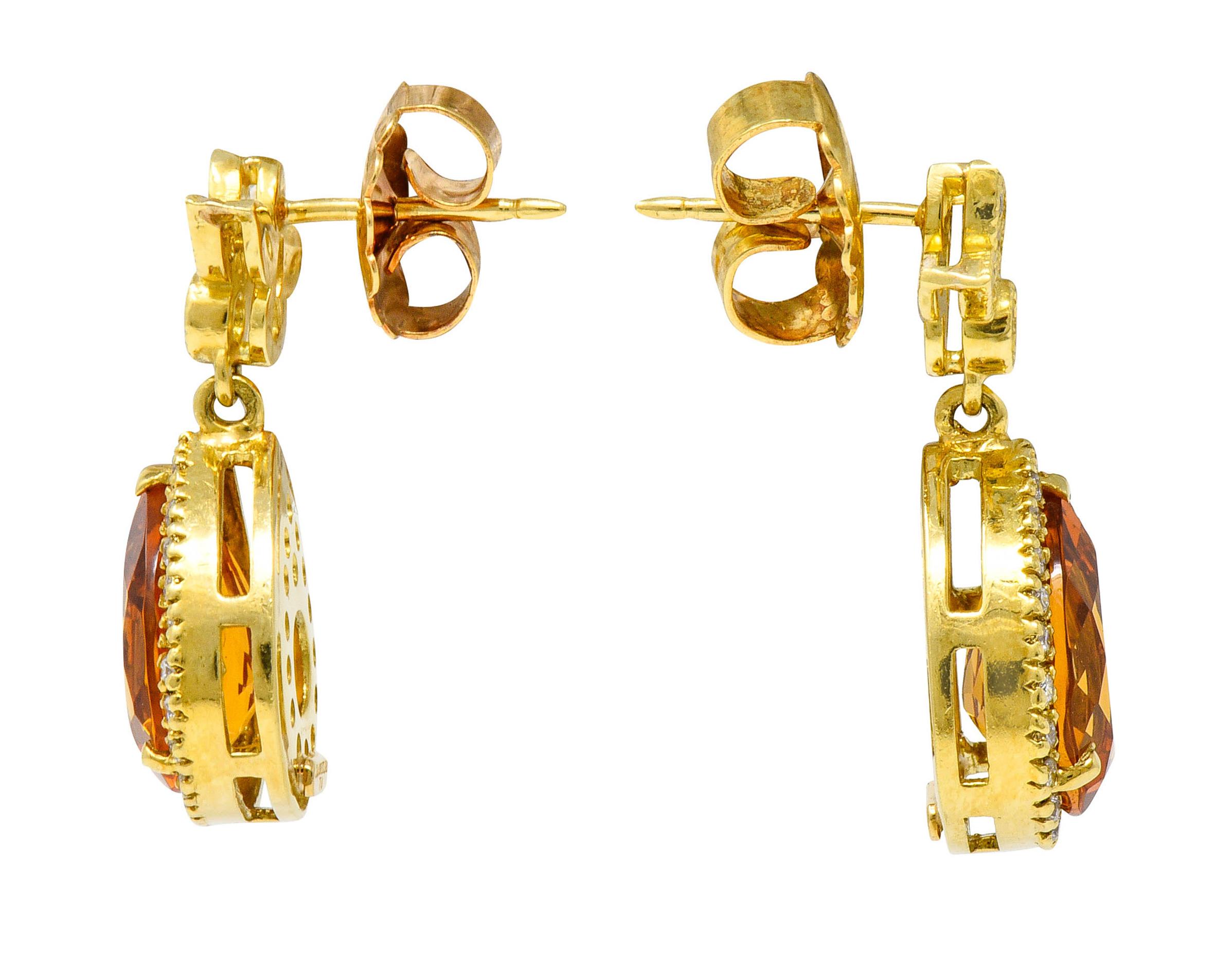 Earrings are designed with a stylized foliate surmount accented by milgrain and diamonds

Suspending an articulated drop centering a pear cut citrine measuring approximately 12.0 x 9.0 mm

Medium-dark orange in color and surrounded by a halo of