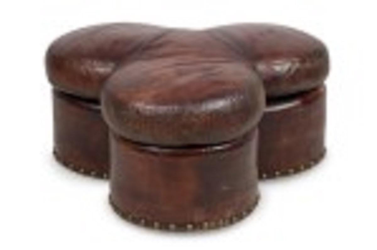 Contemporary brown leather ottoman with a three-lobed clover shape and decorative brass upholstery nail head trim.