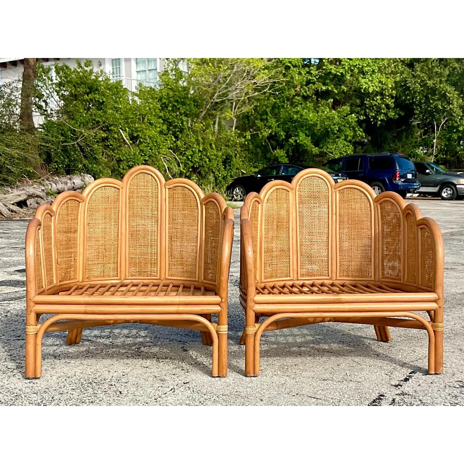 A fabulous pair of Contemporary Coastal lounge chairs. Beautiful scalloped design with chic inset cane panels. Acquired from a Palm Beach estate.