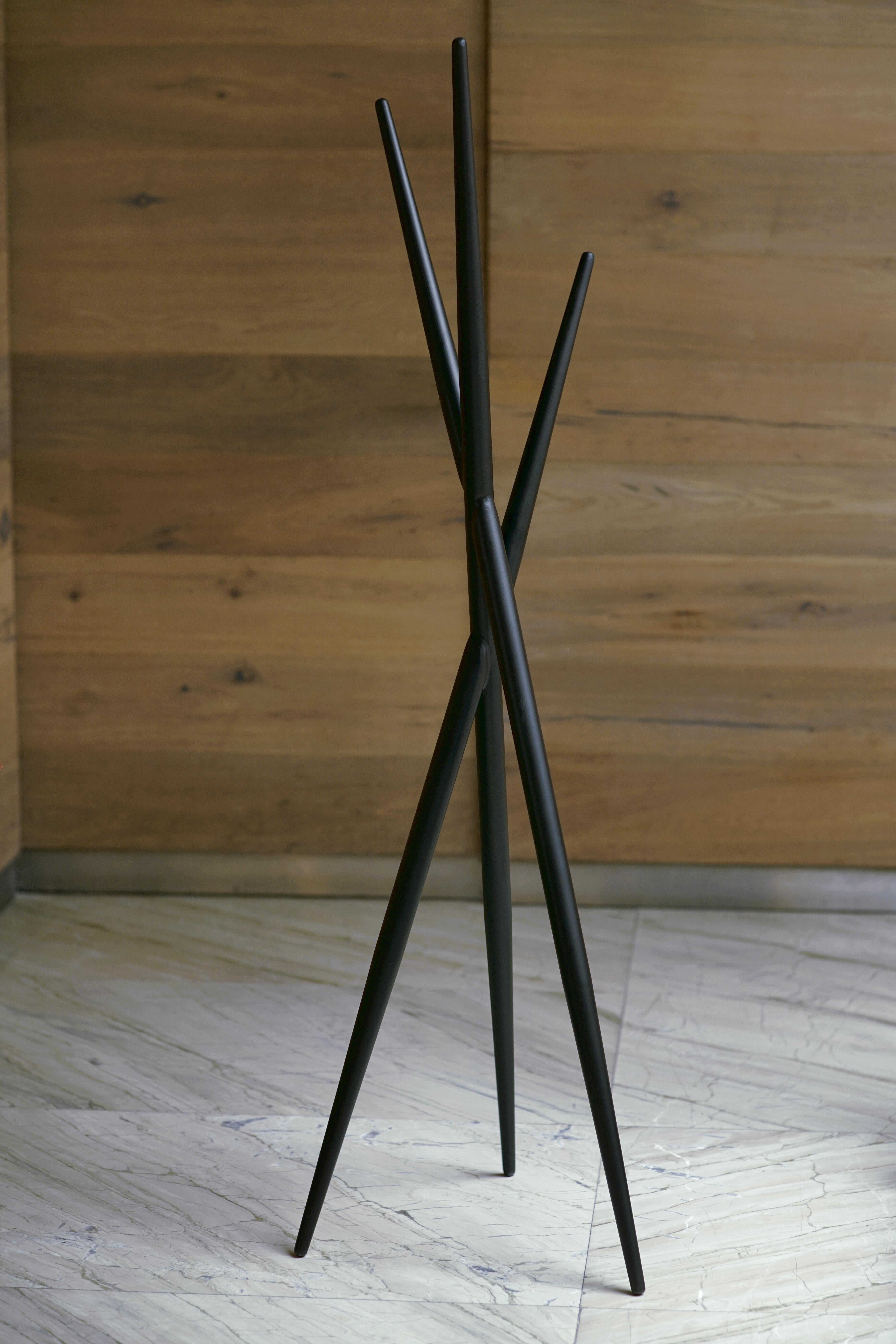 Coat rack 160. Simple, geometrically strong, made of metal electrostatically painted. The rack consists of 3 conical metal tubes intersecting and supporting each other. Available in 160cm high.