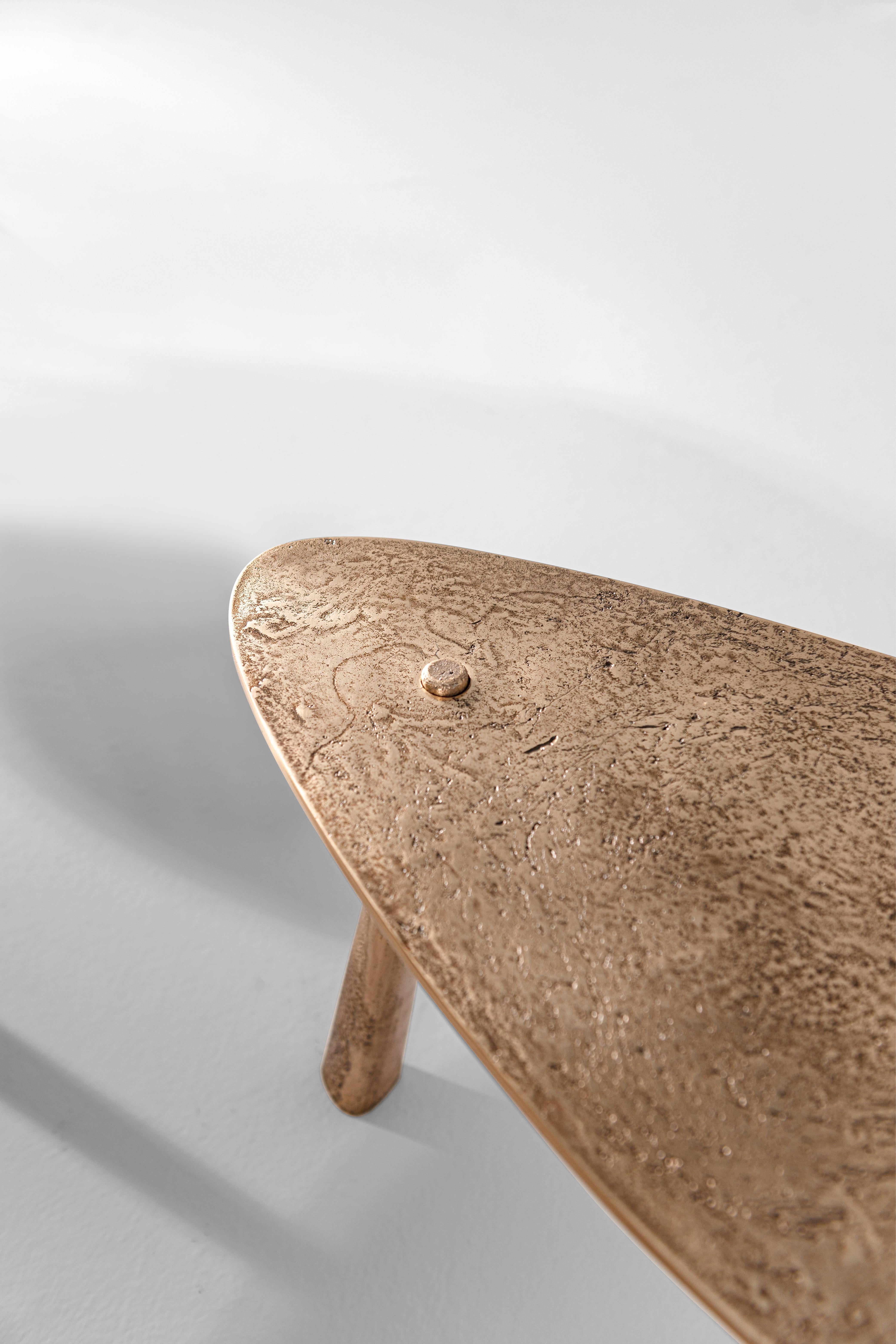 La table basse Drop est fabriquée par un procédé de fonte de bronze, un art ancien datant de plus de 5 000 ans. Il tire son nom de son design minimal mais sophistiqué : trois pieds apparemment coniques traversent un plateau en forme de goutte d'eau.