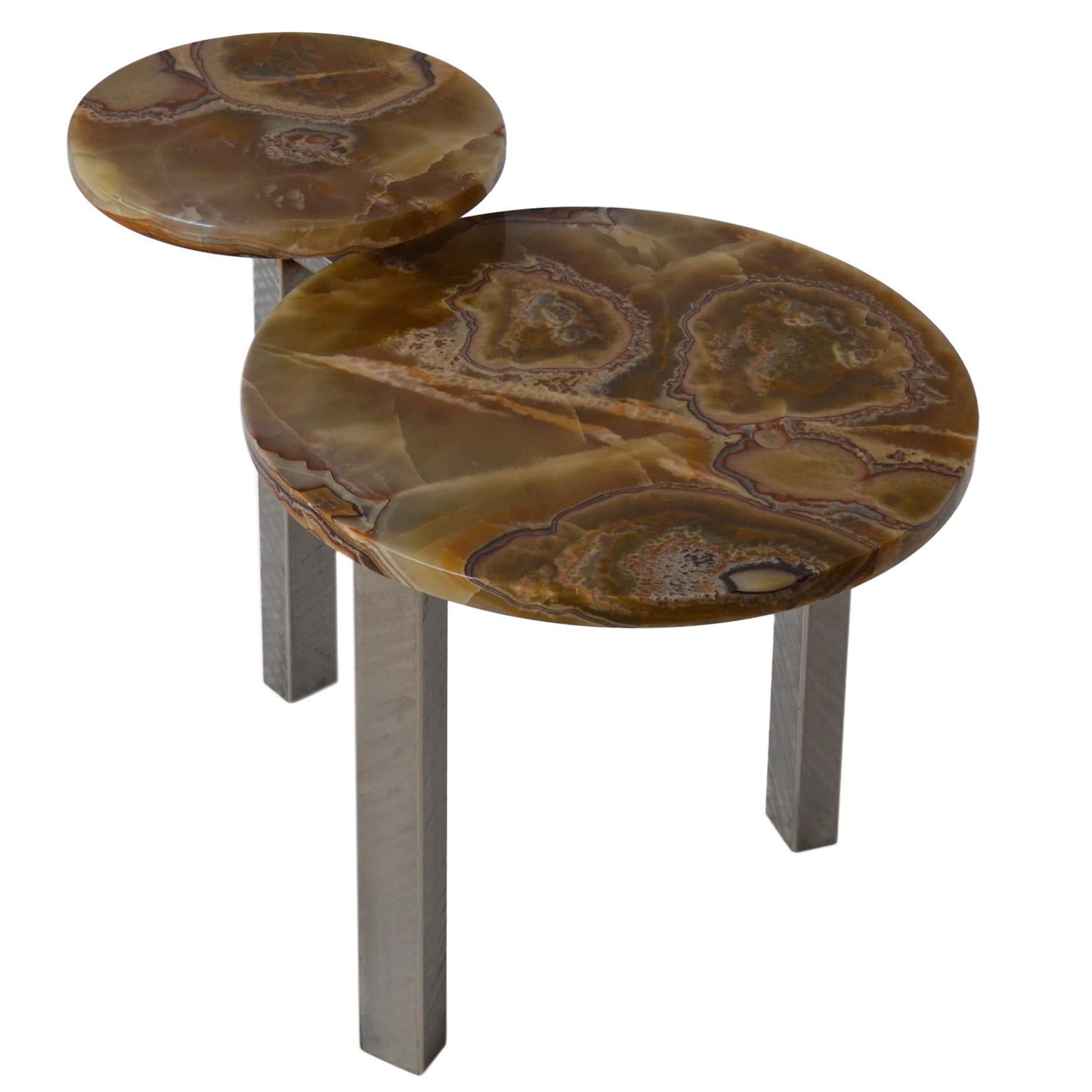 This table is handcrafted using 2 kind of materials as grinded-finished stainless steel for the three legs and elegant Onyx on the two tops. The table has a functional use, based on two levels of tops and it is an elegant choise for a modern or