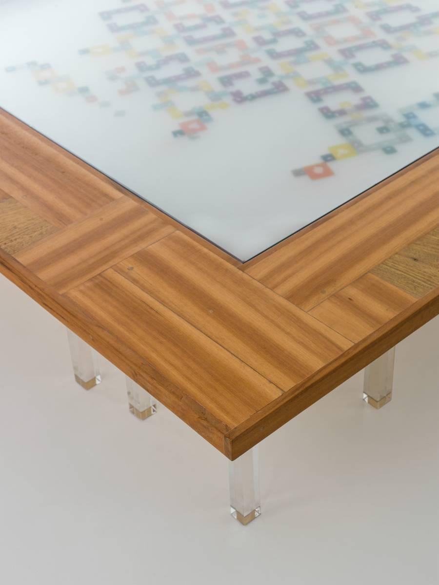 The mosaiced coffee-table Cobogó is made of handcrafted wood, resin and acrylic.
The shape of the 16 table legs made of transparent acrylic recall the palafitts of Amazon river houses which were raised on piles to protect them against flooding.