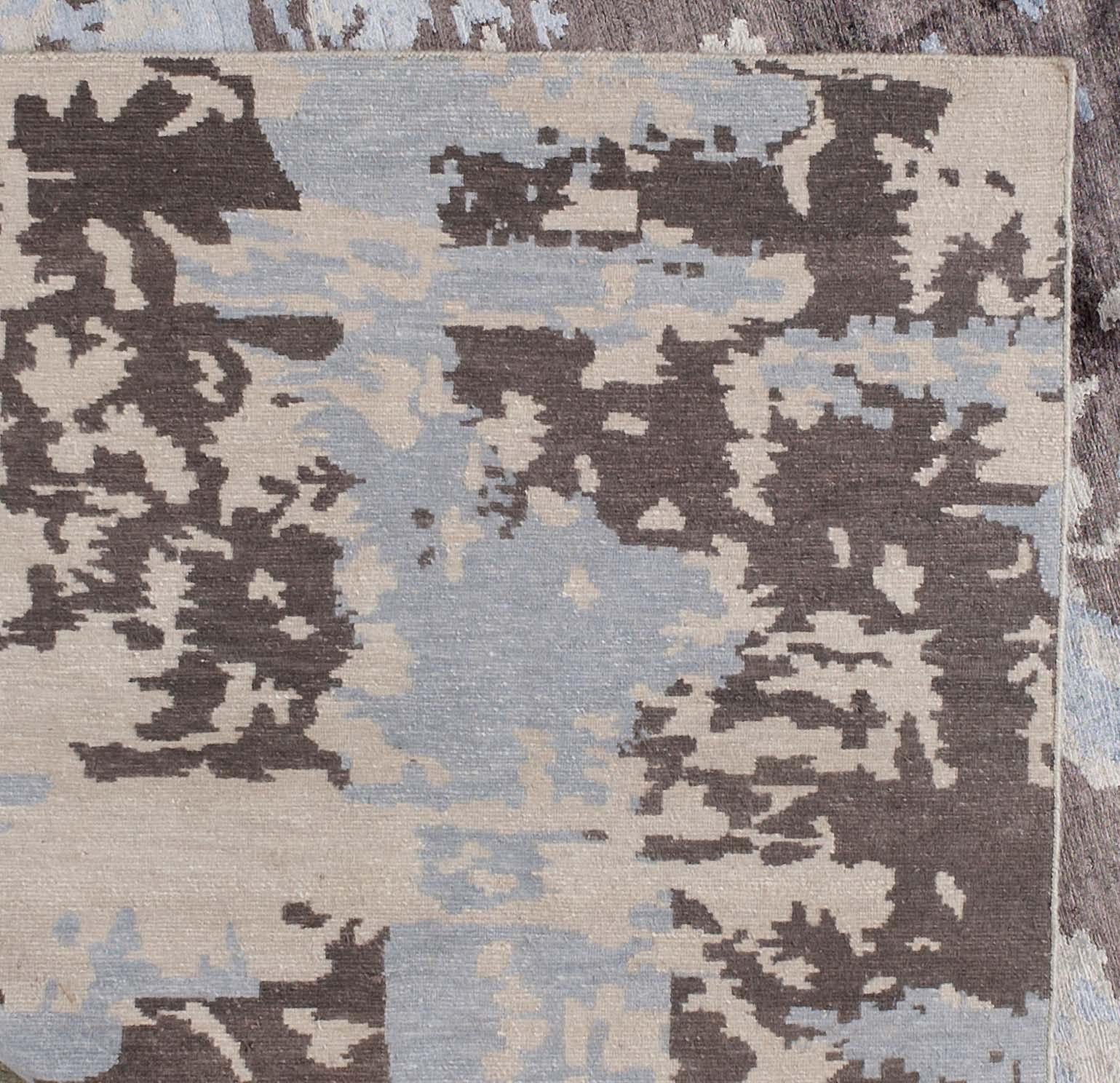 A very modern abstract mix of silver/gray, beige and taupe make for a very versatile rug, well-suited for a wide range of design styles. Hand knotted in India.