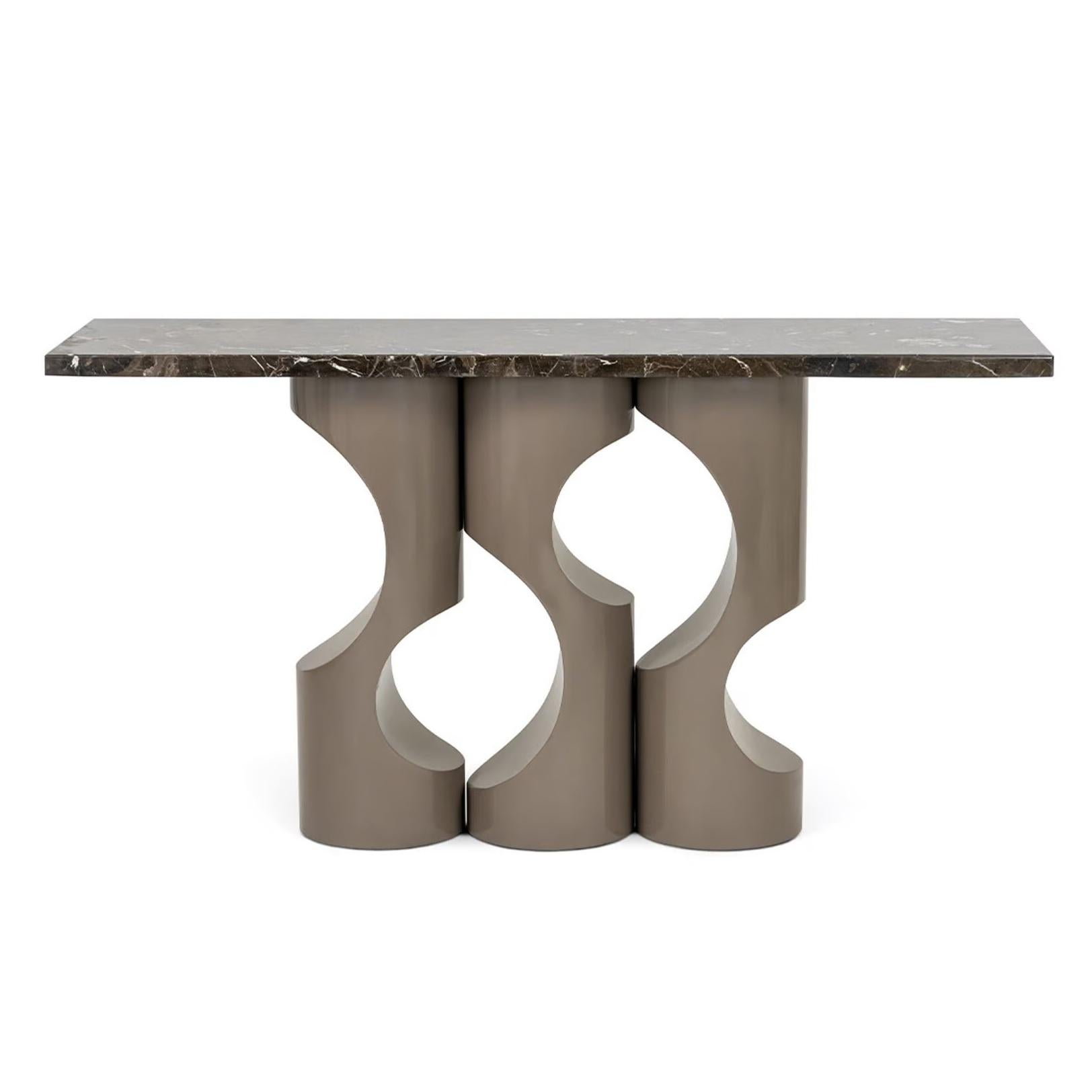 Esta consola presenta un diseño elegante y moderno con elementos distintivos que contribuyen a su atractivo estético general. Las tres patas cilíndricas proporcionan una estructura de soporte estable y equilibrada para la consola. El tablero es de