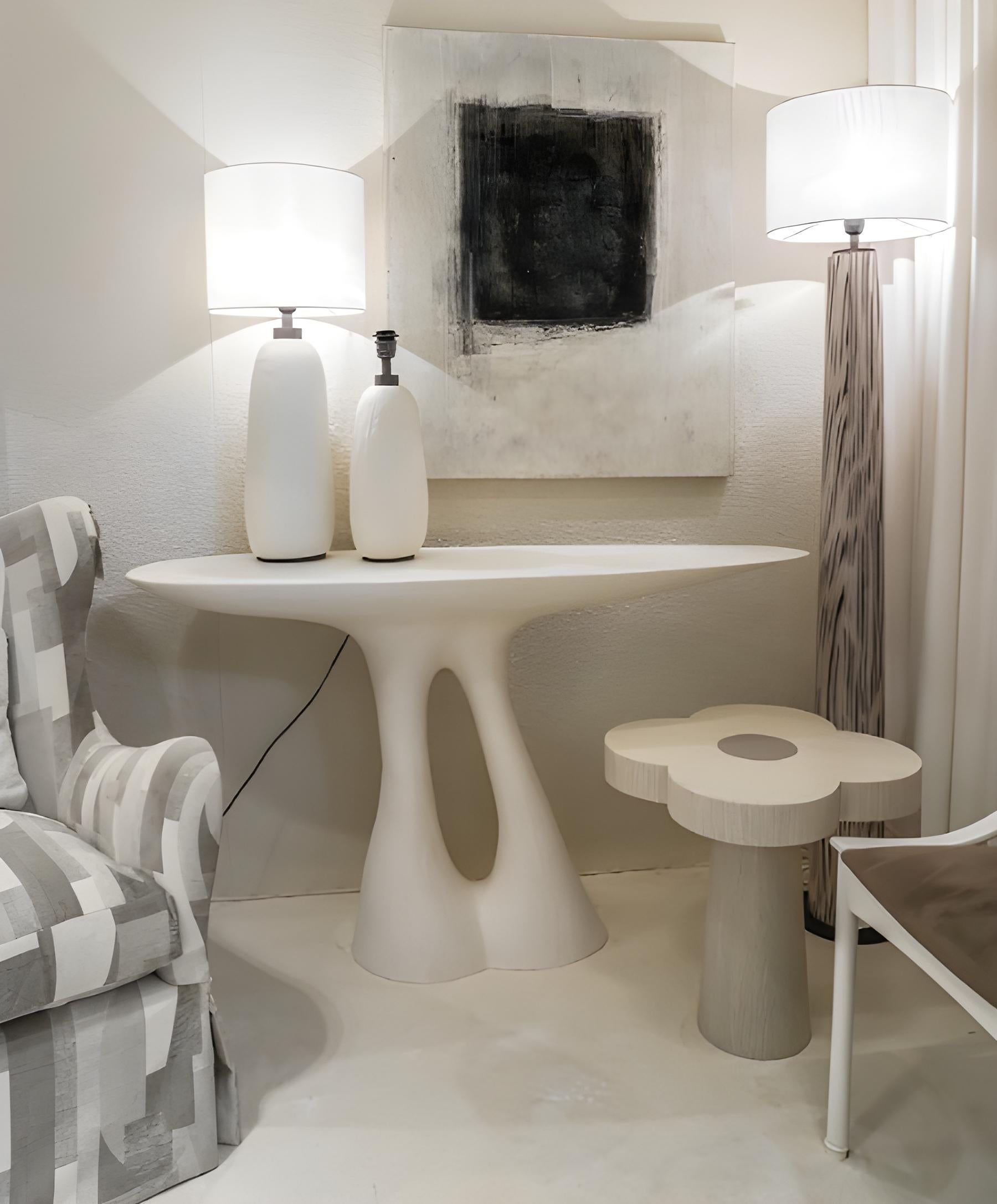 This captivating console is a testament to organic design, where form and texture converge to create a truly unique piece. Its entire structure is enveloped in a meticulously applied plastered finish, lending a raw, tactile quality that invites