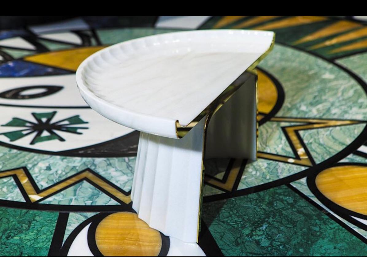 This particular marble table is part of the Corinthia collection that includes both round and angled editions. A collection of Italian crafted low tables entirely in white marble with section bars in shiny brass, harks back to a more classical past.