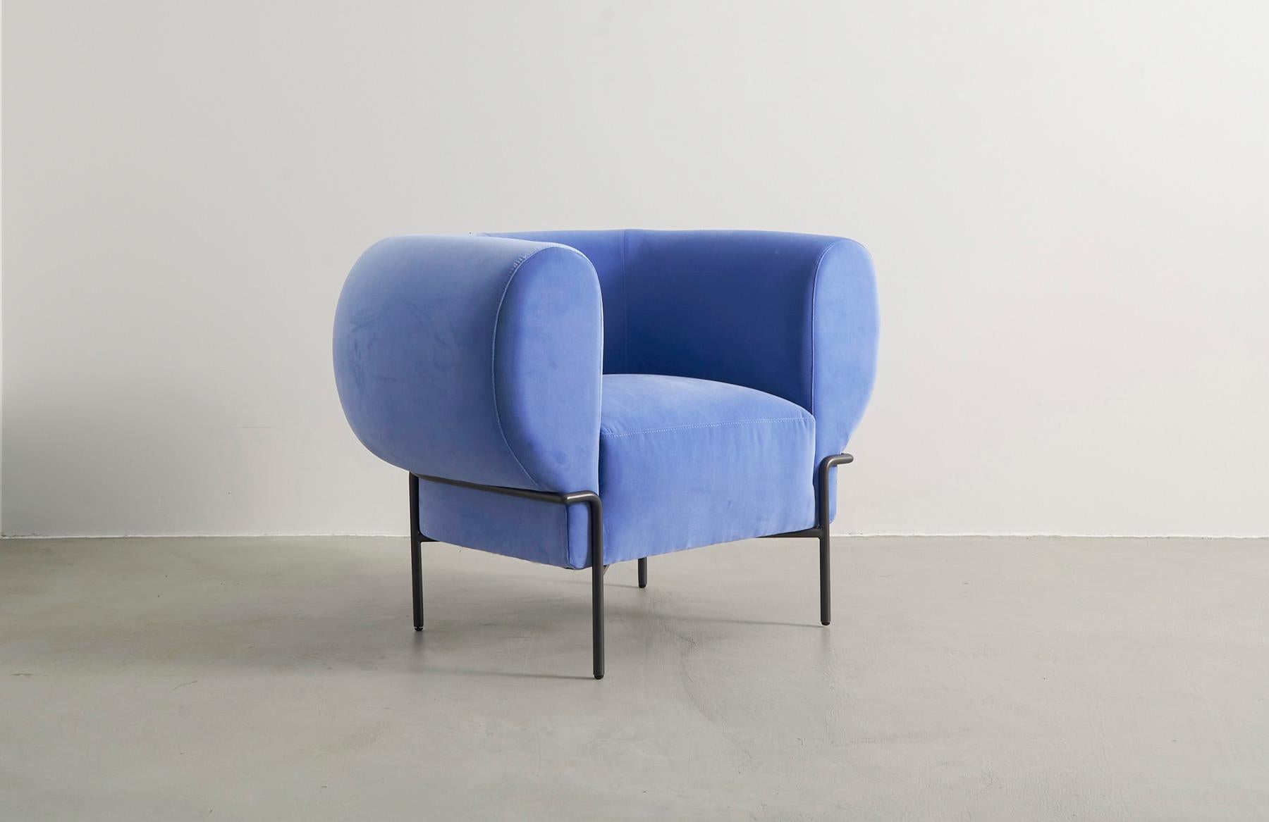 Der Madda von Michael Felix ist ein zeitgenössischer, moderner und minimalistischer Sessel aus Samt, inspiriert von der Interpretation klassischer Clubsessel aus der Mitte des Jahrhunderts. Der Metallfuß umschließt das pralle Kissen, als würde er