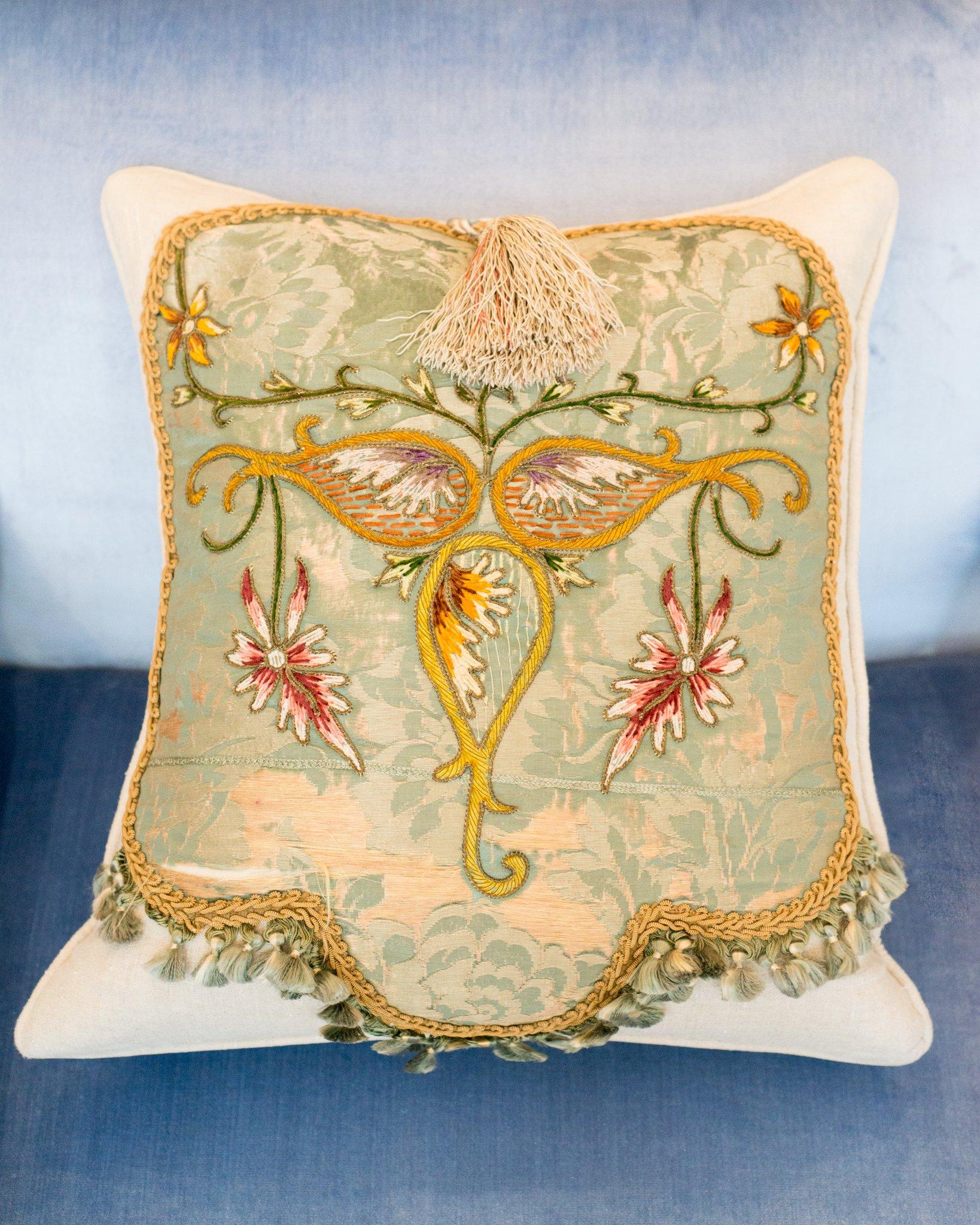 A beautiful cream linen pillow with antique embroidered panel, tassels and metallic rope trim. Filled with 100% Canadian Down and Feather insert.