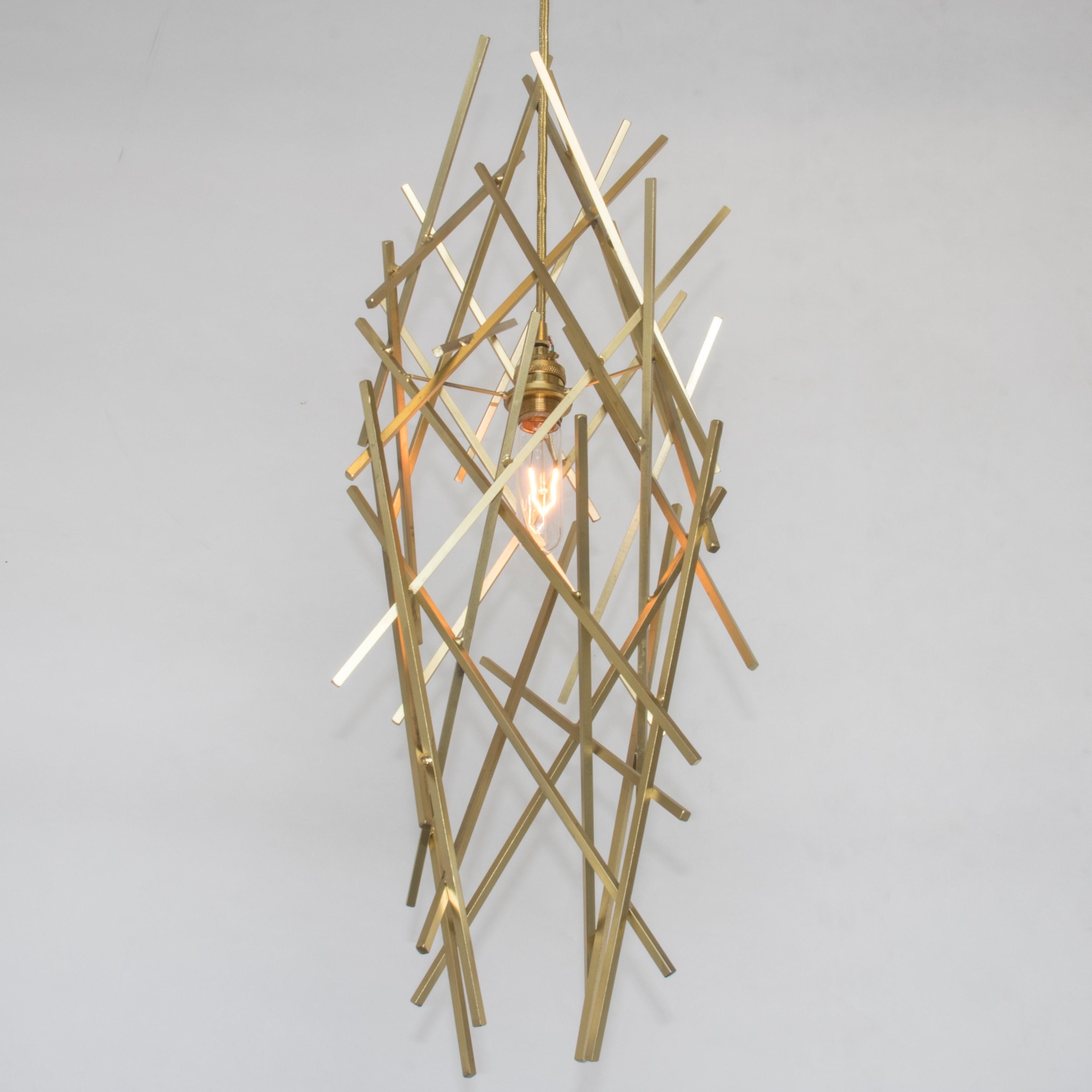 The CRISS-CROSS Pendant is composed of artistically welded steel square rod. Each piece is uniquely handmade and while similar, no two fixtures are alike.

Shown in Satin Brass with premium Brass socket and woven cord. 

Dimensions: 9