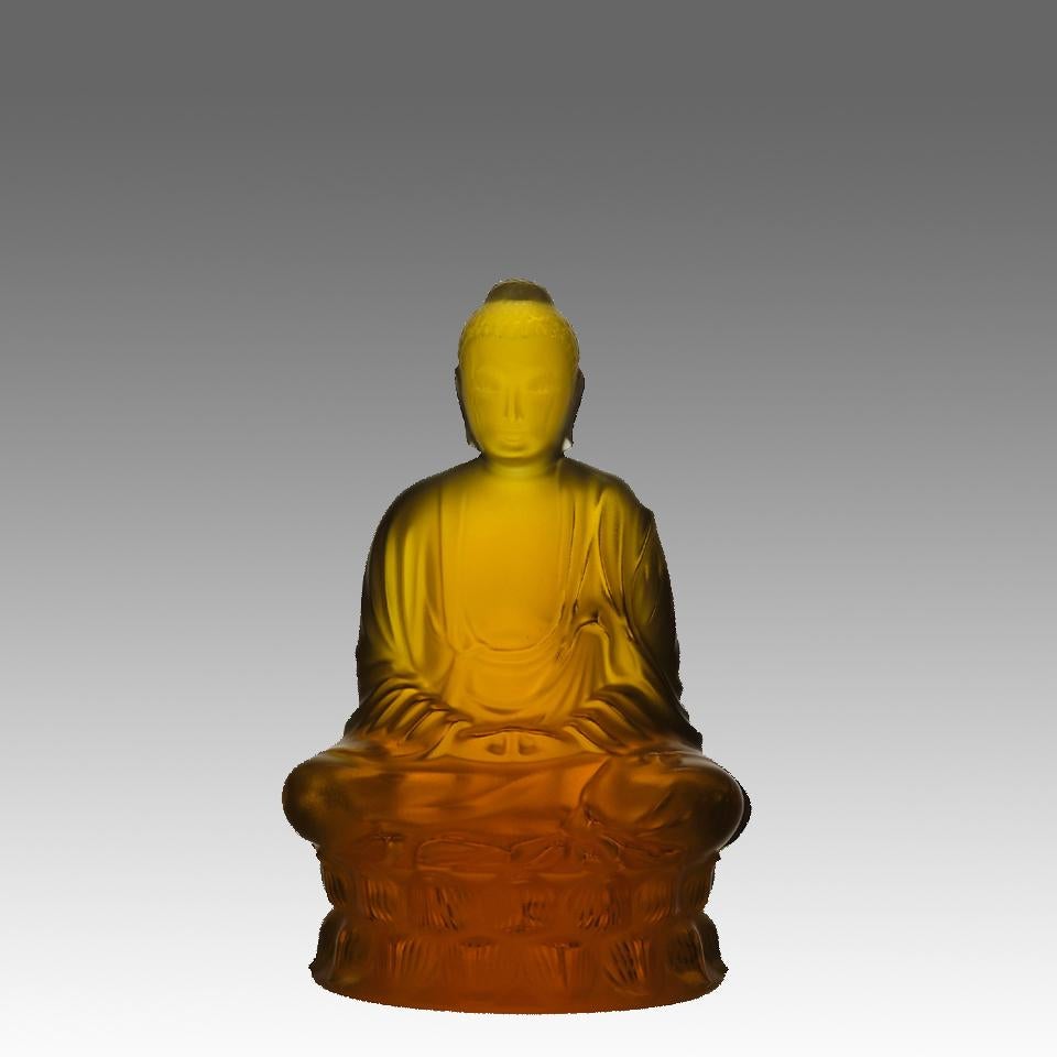 Un'accattivante scultura in edizione limitata che raffigura il Buddha seduto in vetro cristallino ambrato, realizzato in cristallo lucido con finitura satinata, il Buddha presenta curve generose e un sorriso gentile. La bellezza del design è