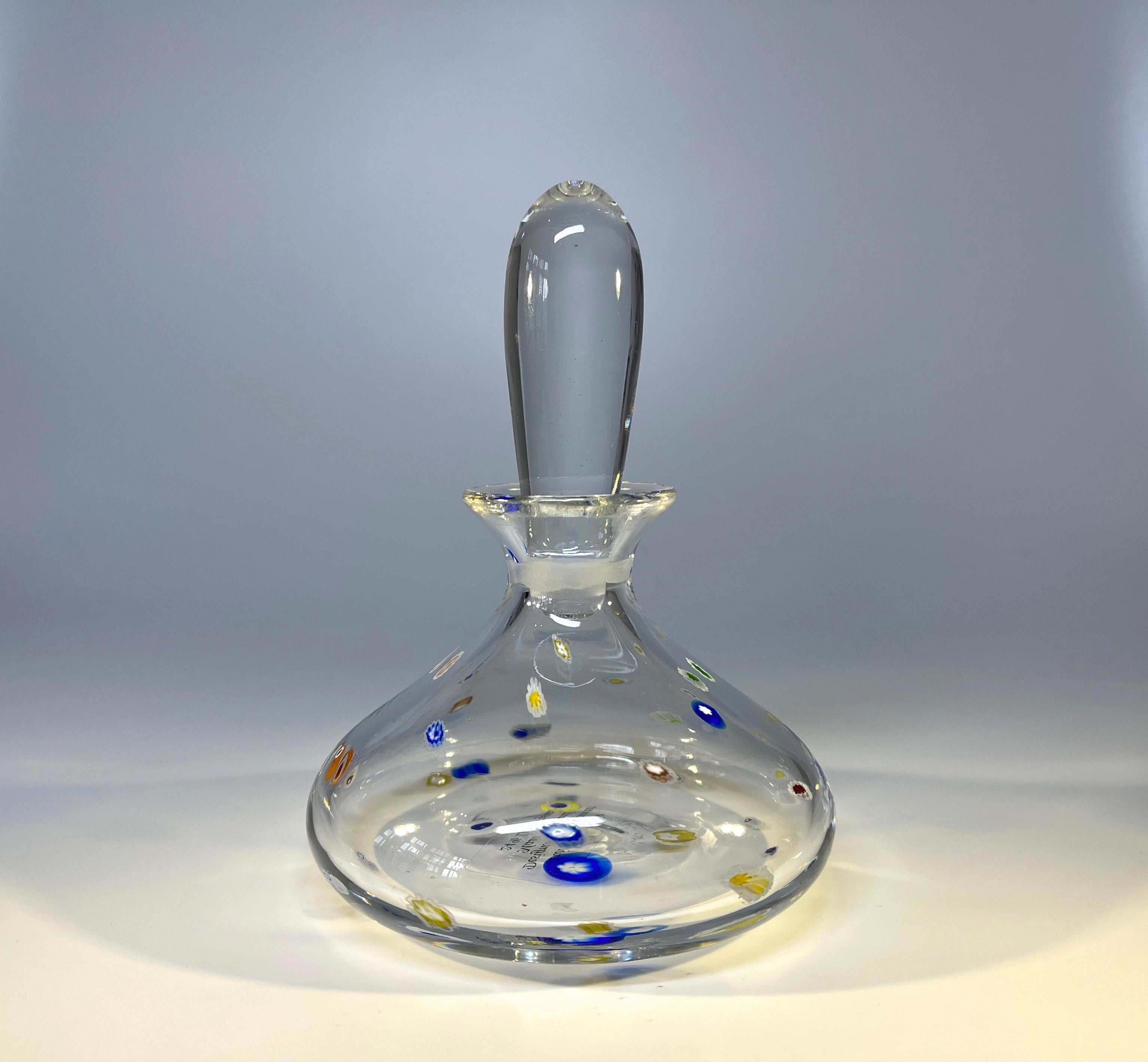 An elegantly designed perfume bottle of clear crystal, decorated with a confetti of colourful murine inclusions. 
Created by renowned glass blower, Mike Hunter of Twists Glass Studio in Scotland.
Signature etched to base, has original studio