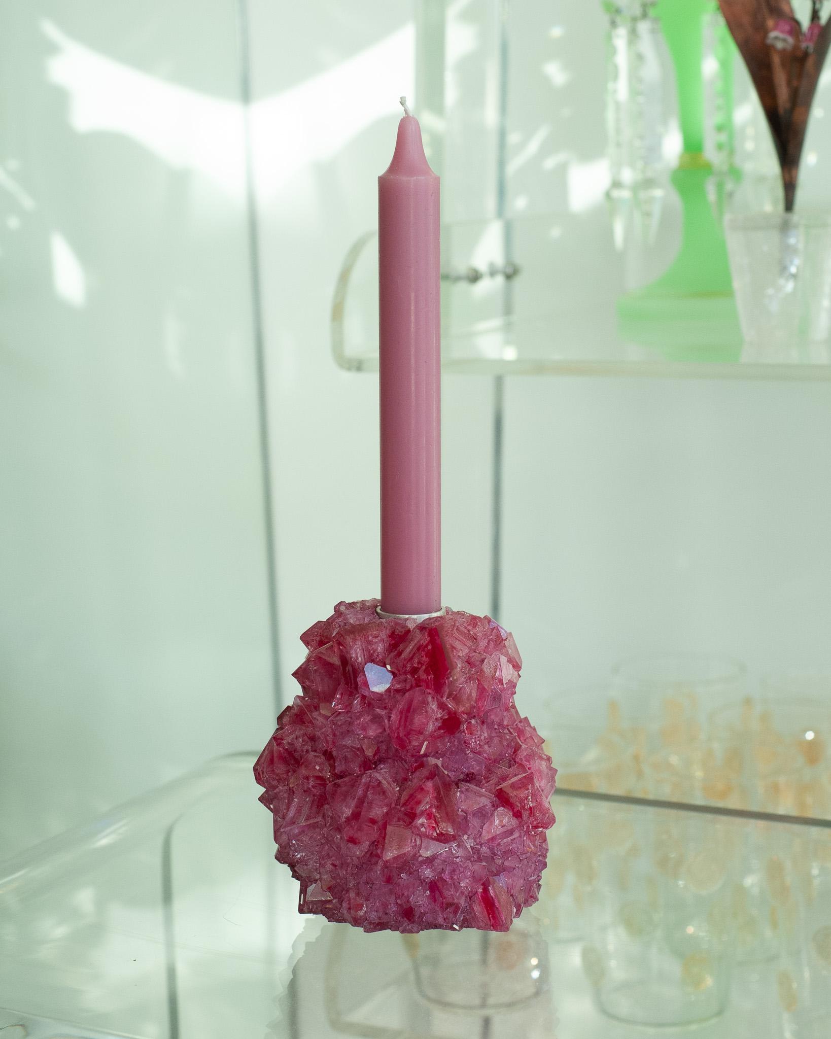 A stunning crystallized candleholder in fuschia, by artist Isaac Monté. This original work of art is produced through fascinating process, combining science and art. By dissolving minerals and oxides in hot water, the artist forms a solution that