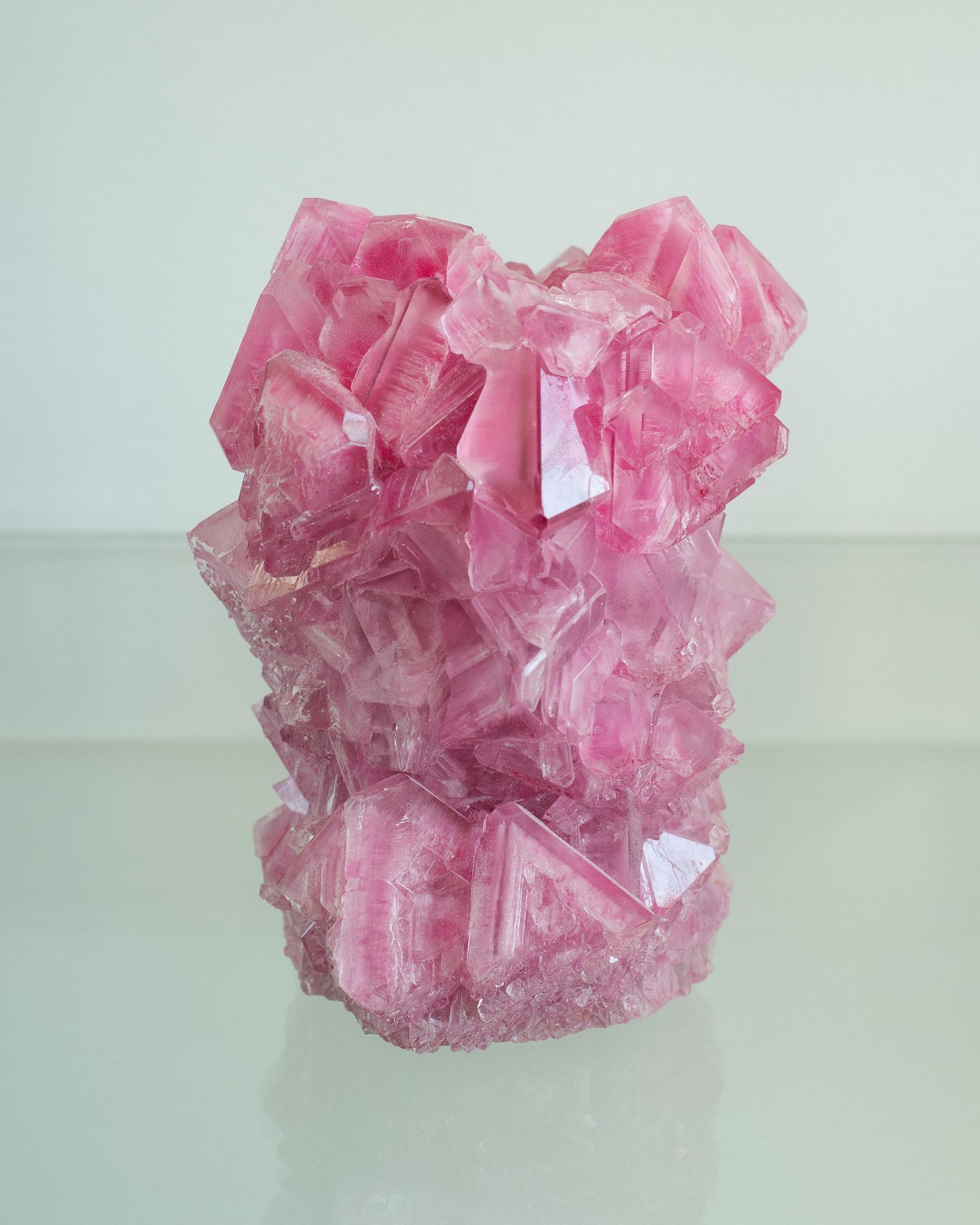 Uno splendido vaso cristallizzato di colore rosa, opera dell'artista Isaac Monté. Questa originale opera d'arte è prodotta attraverso un processo affascinante, che unisce scienza e arte. Sciogliendo minerali e ossidi in acqua calda, l'artista forma