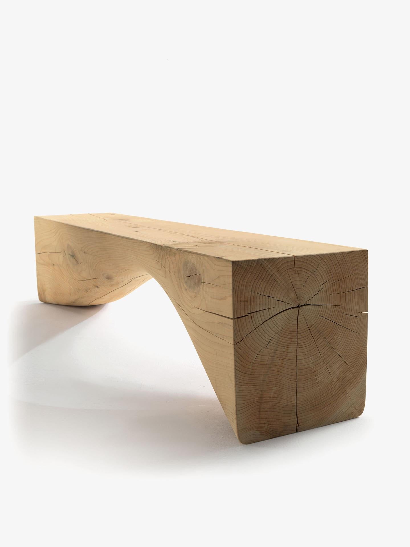 Bench in a single block of scented cedar. Distinguished by its arched shape below the seat that exalts the wood grains and the shades of the natural cedar.