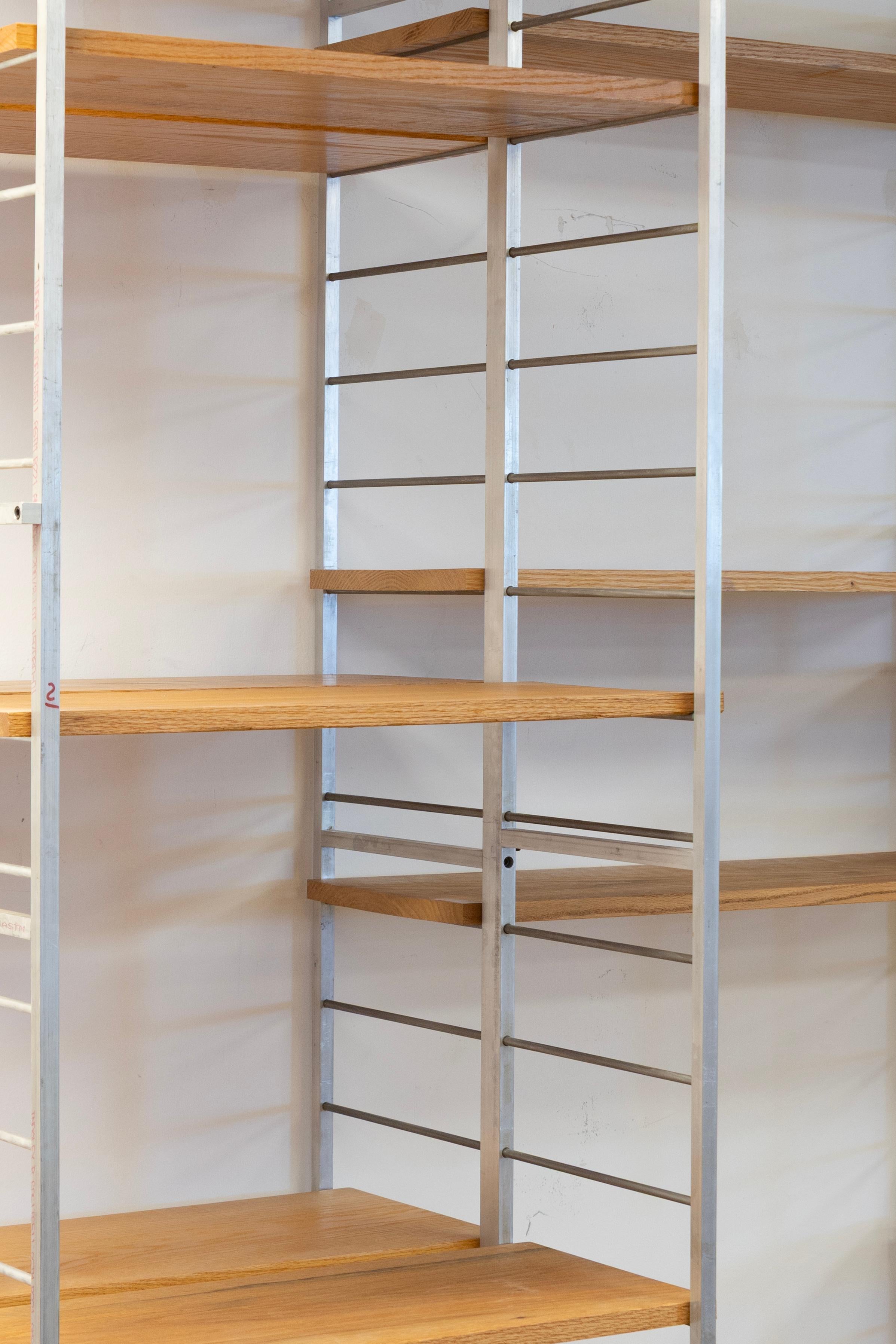 Exemple frappant de design industriel minimaliste, cette étagère murale modulaire présente une combinaison élégante d'étagères en bois massif et d'un cadre en métal brossé. Le cadre ouvert et la structure en gradins de l'unité offrent un aspect