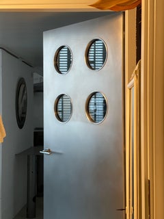 Contemporary custom made Spinzi stainless steel metal door with round portholes