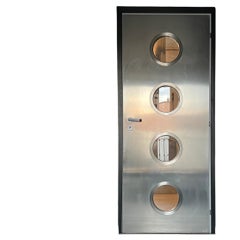 Contemporary custom made Spinzi stainless steel metal door with round portholes