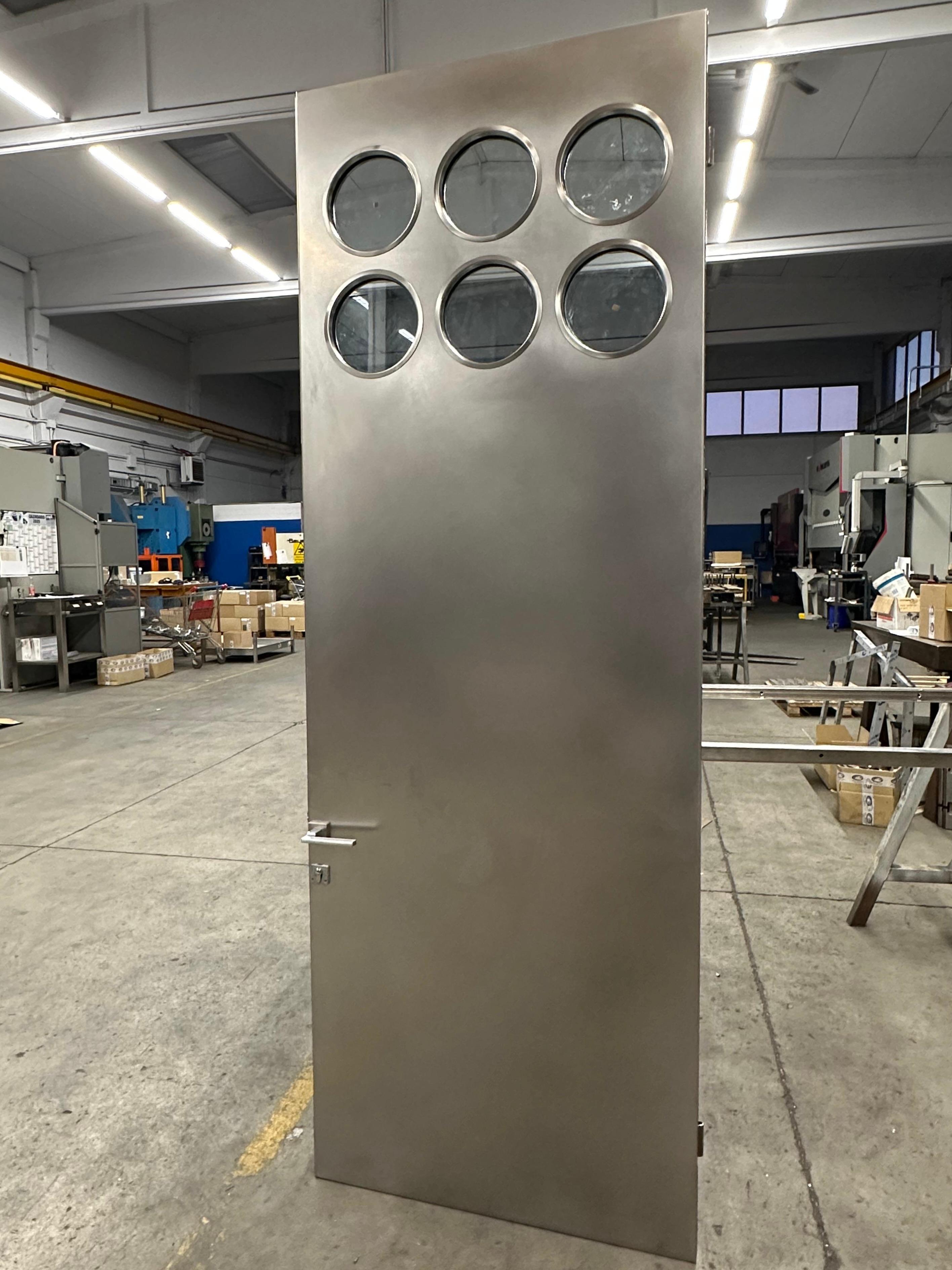 Industrial Contemporary custom made Spinzi stainless steel metal door with round portholes For Sale