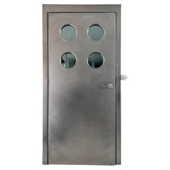 Porte métallique contemporaine sur mesure en acier inoxydable Spinzi avec hublots ronds