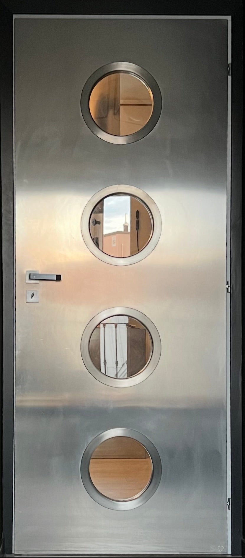 Porta contemporanea in metallo su misura in acciaio inox Spinzi con oblò rotondi