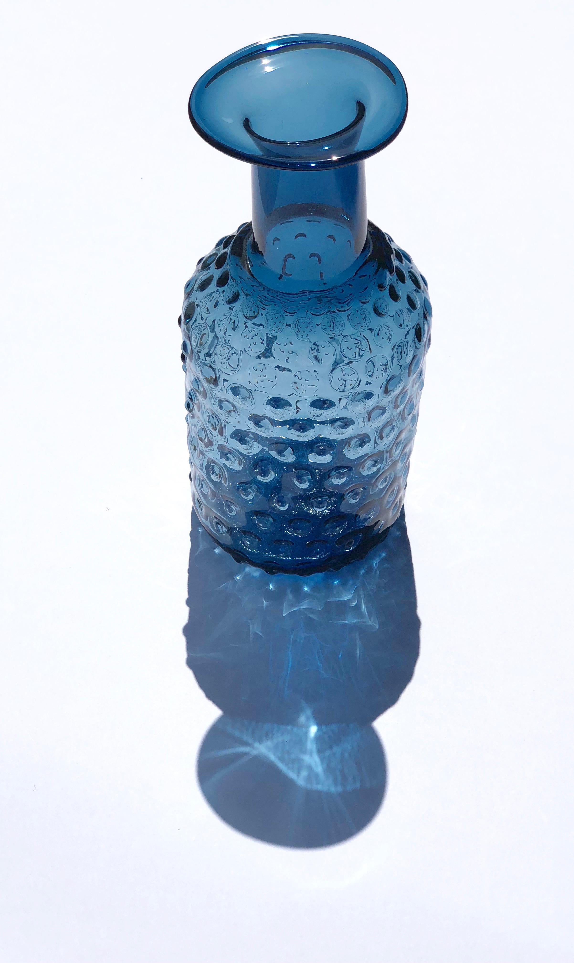 Contemporary Czech studio glass vase or bottle with bumpy facade. The bumps are actually like small optical elements that when viewed up close, you can see an optical illusion that each bump is full of bumps. The form is playfully gestalt end