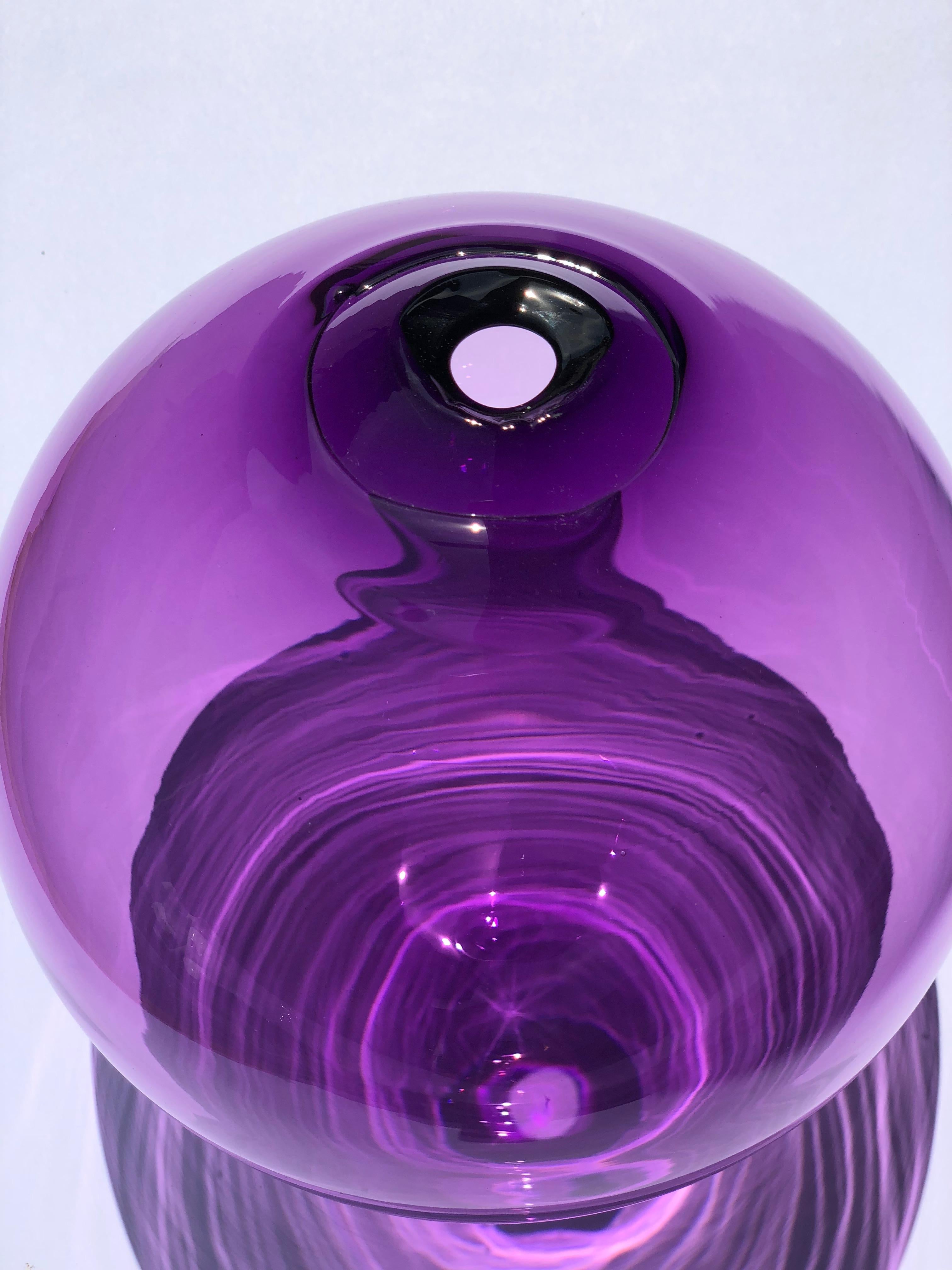 Zeitgenössisches Studioglas, hergestellt in der Tschechischen Republik. Dieses mundgeblasene Stück besteht aus einer organischen, runden Form mit einer transparenten violetten Farbe. Die Unvollkommenheiten (unterschiedliche Dichte des Glases,