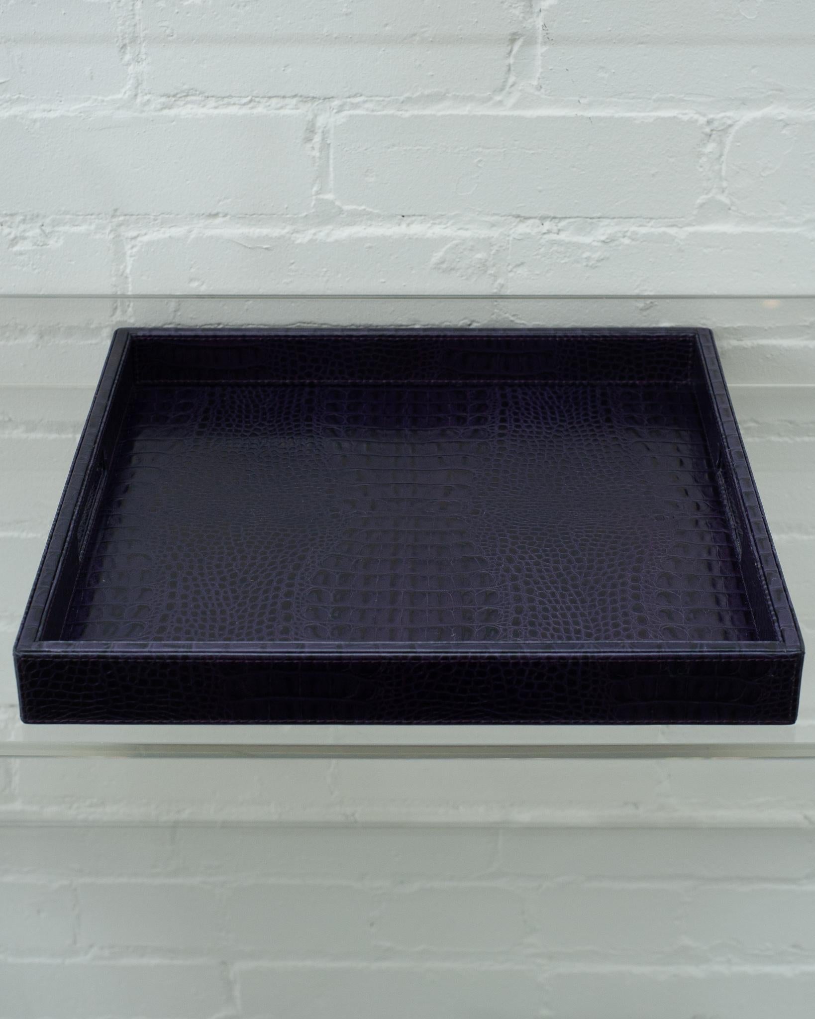 A beautiful deep purple crocodile embossed leather tray, perfect for the desk, bedside table, or use as a serving piece. Fully wrapped in embossed leather with stitched panels, each tray has two openings for carrying.