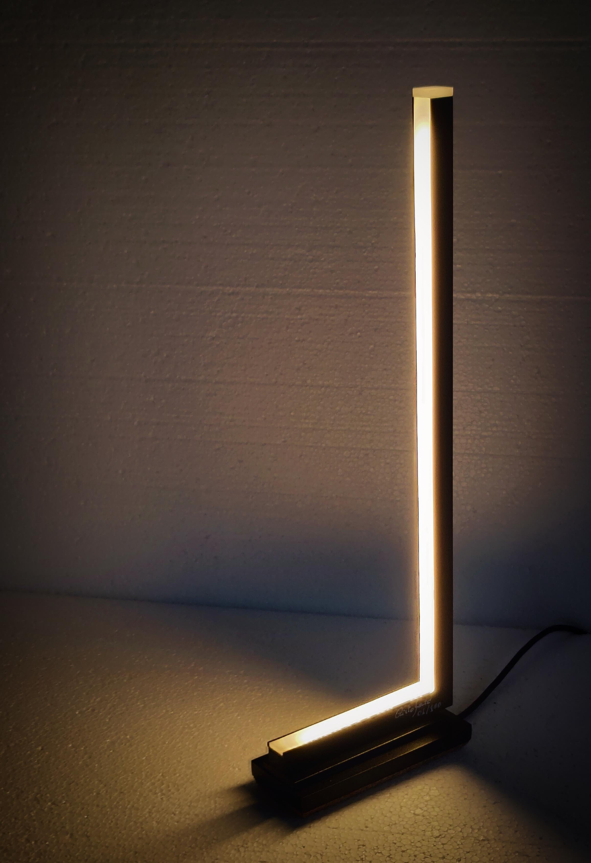 Lumè table lamp was born as a study prototype of the LUME ‘floor lamp. A unique small table lamp, Lumè (the small) is one of our newest pieces. 
A play of lines and overlapping volumes of matter that integrate bands of warm light distorted by