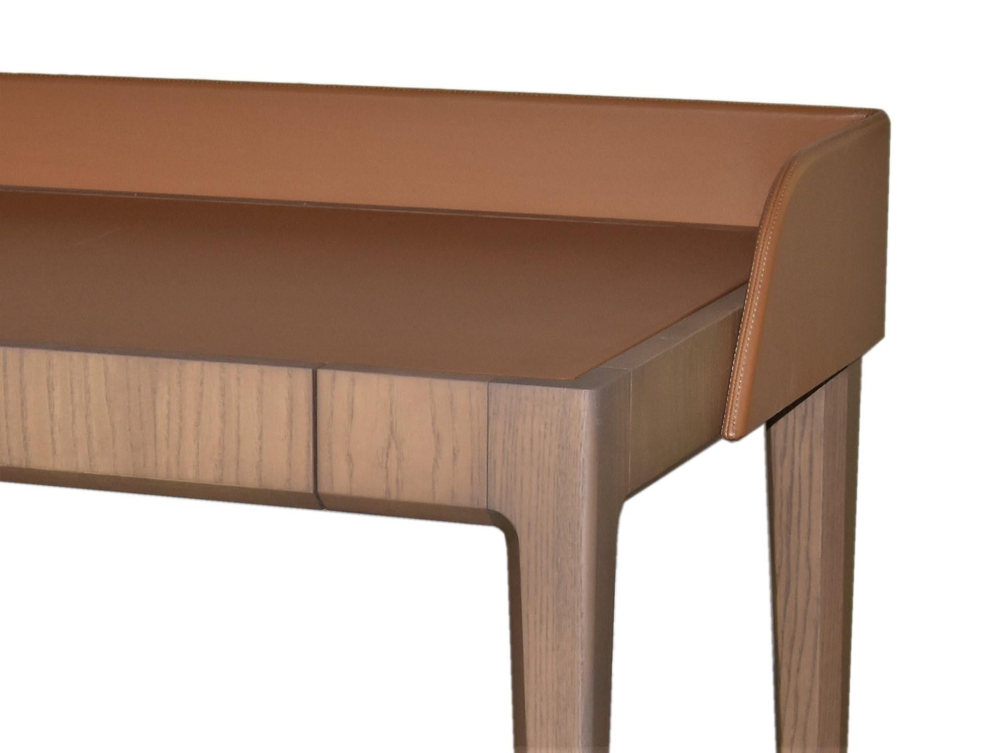 Contemporary style Bellagio writing desk made of ashwood with leather flapping top, characterized by angled bevels, which make the structure thinner and lighter, though resistant. 

Design Libero Rutilo.

Available in different wood colors and