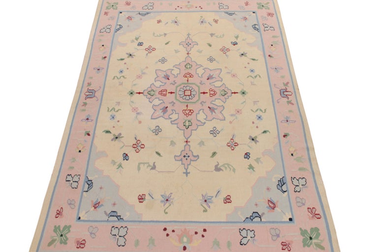 Handwoven in wool, a square 5x9 flatweave designed by one of the most modern designers in India—partner to Rug & Kilim. Acknowledged as a Dhurrie flatweave, this style features a sublime medallion in whimsical pink & pastel blue on a beige backdrop,
