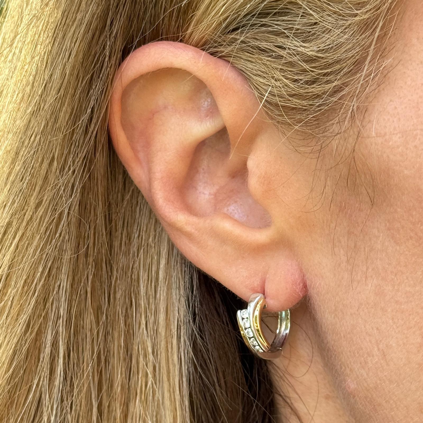 Questi eleganti cerchi huggie in oro 14 kart bicolore combinano l'eleganza dell'oro bianco con il calore dell'oro giallo per un look versatile e contemporaneo. Ogni orecchino è incastonato con 10 diamanti tondi taglio brillante per un totale di