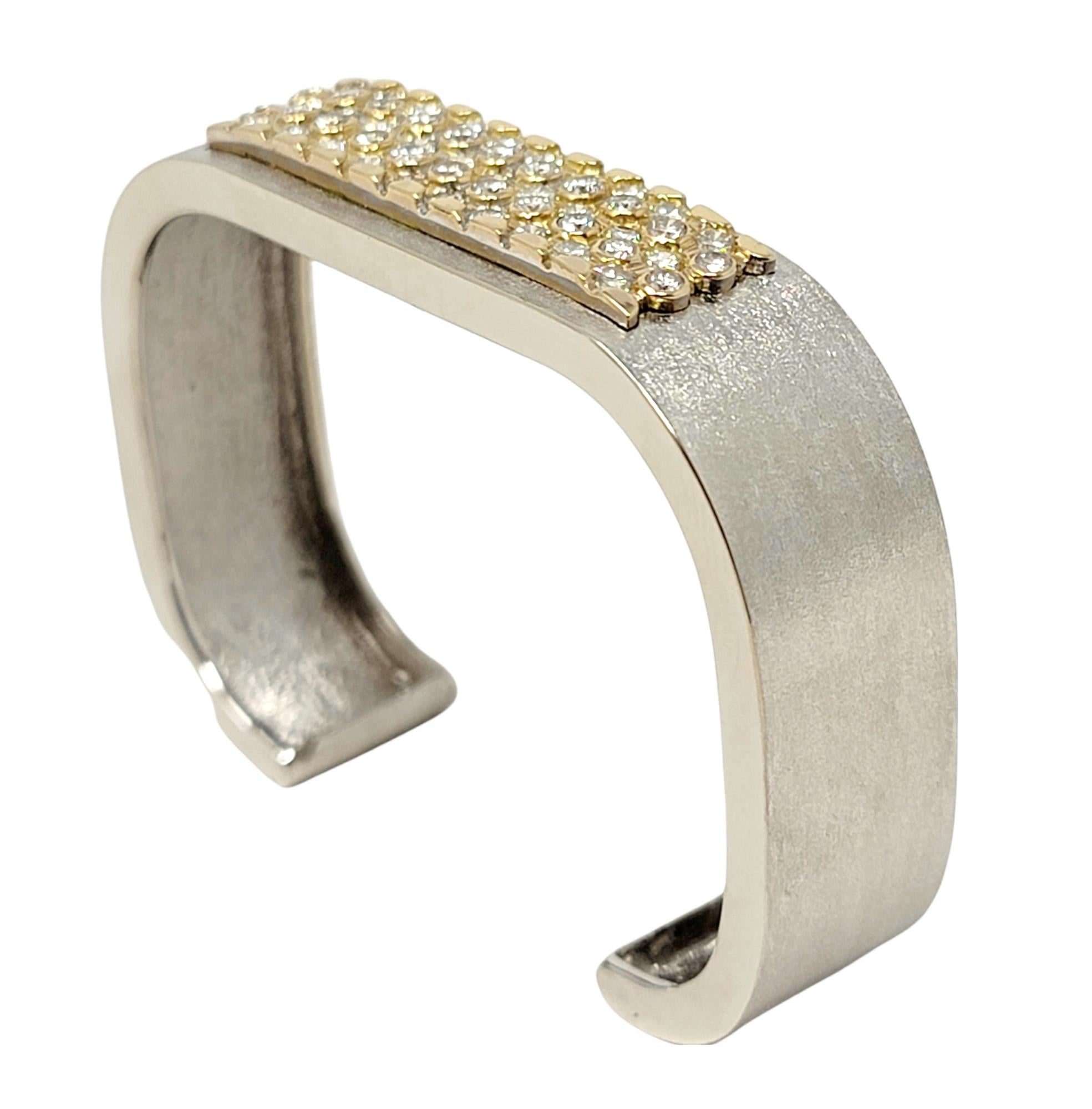 Breathtaking contemporary diamond cuff bracelet shimmers beautifully on the wrist. This stunning piece features a slightly squared design with a modern brushed gold finish. The 52 glittering round brilliant diamonds are arranged in 5 alternating