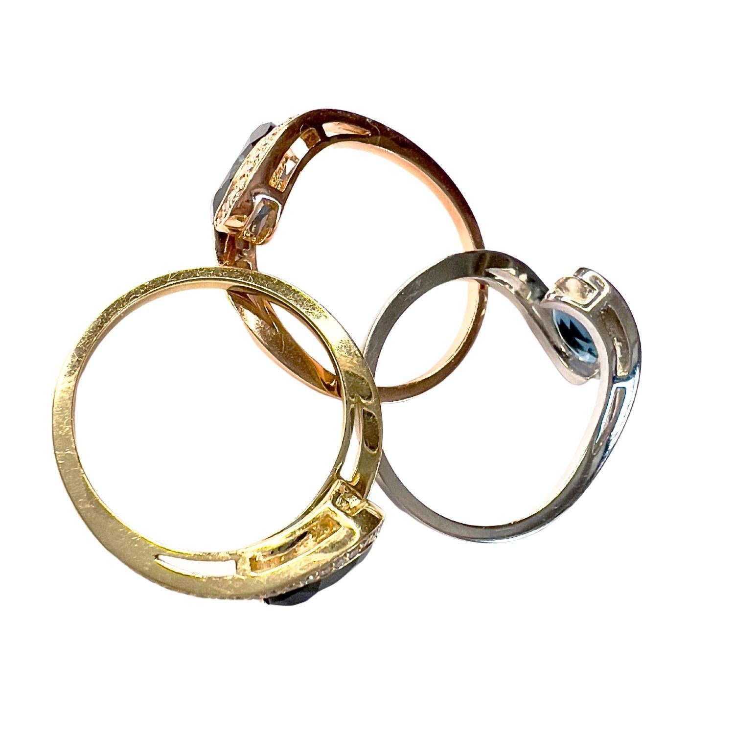 This contemporary ring is crafted in 14K tri-color gold (red, yellow, and white) and features brilliant-cut Diamonds and a central cobalt Topaz. 

It has a combined weight of 7.71 grams (2.65 grams each unit) and is sized 16/56. 

The Diamonds total